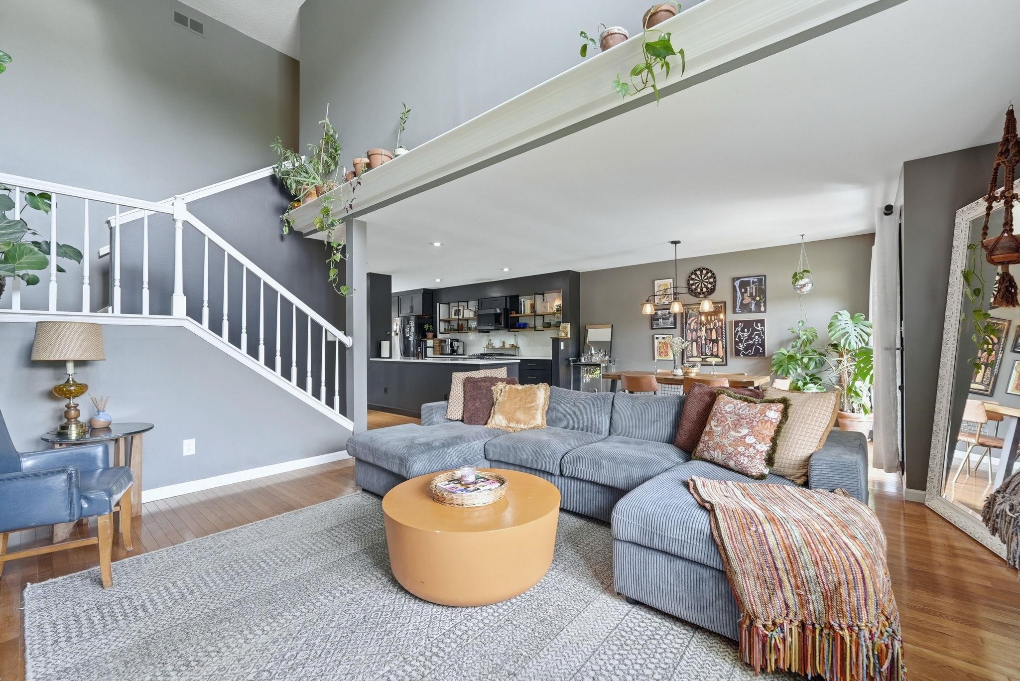 Open-concept living area with high ceilings and wood-finish flooring