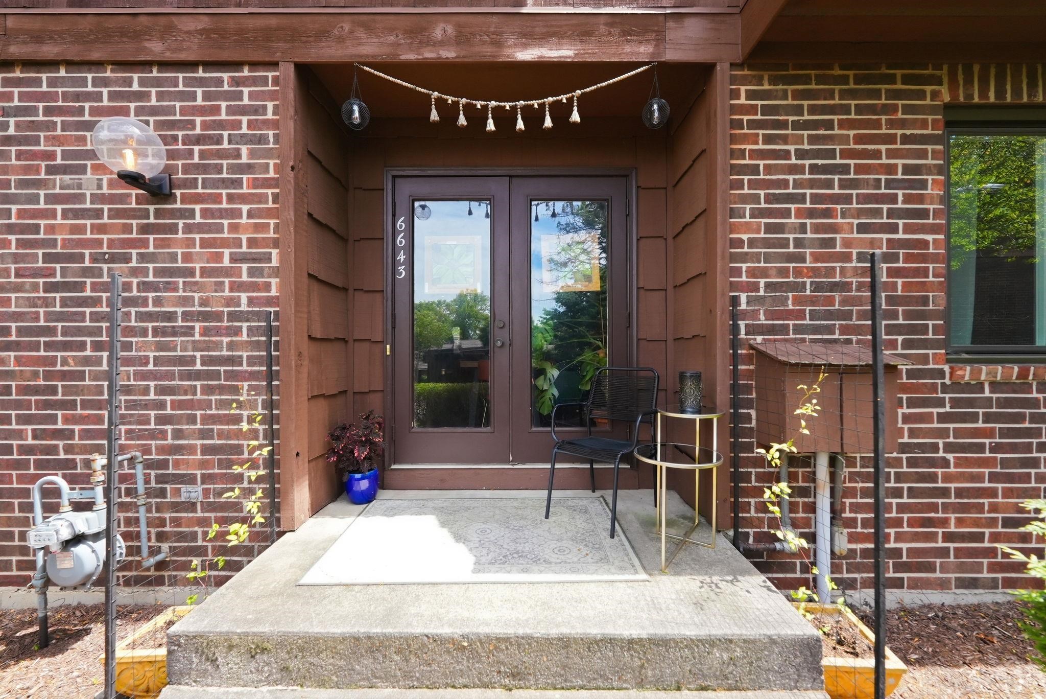 Brick exterior with a recessed entryway featuring double glass-panel doors