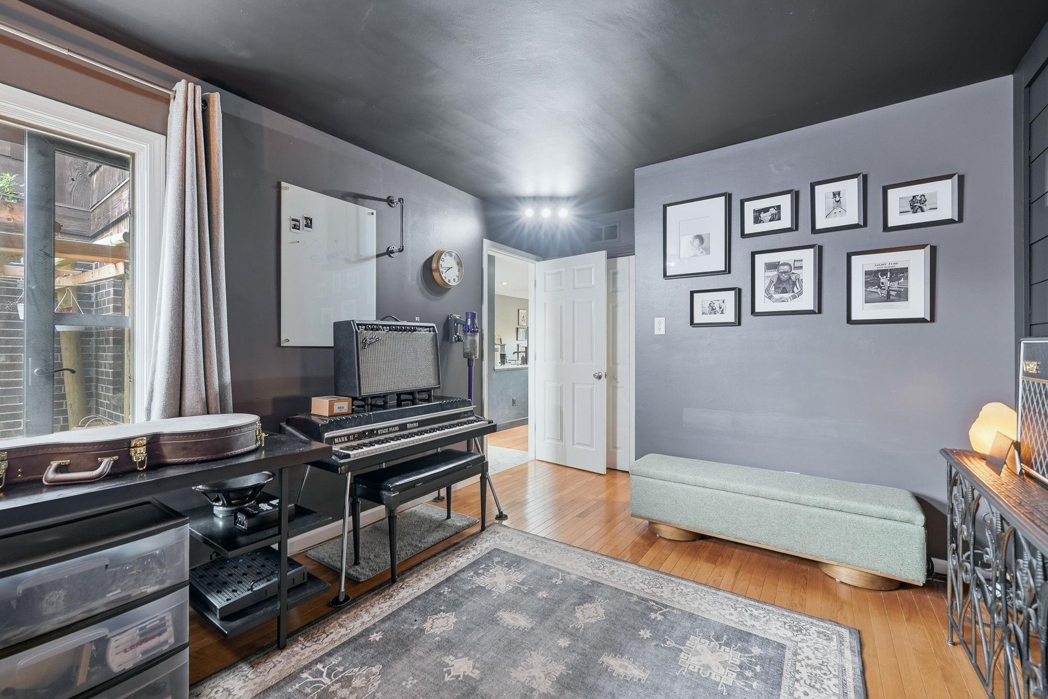 Interior room with hardwood flooring, dark gray walls, and a matching dark ceiling