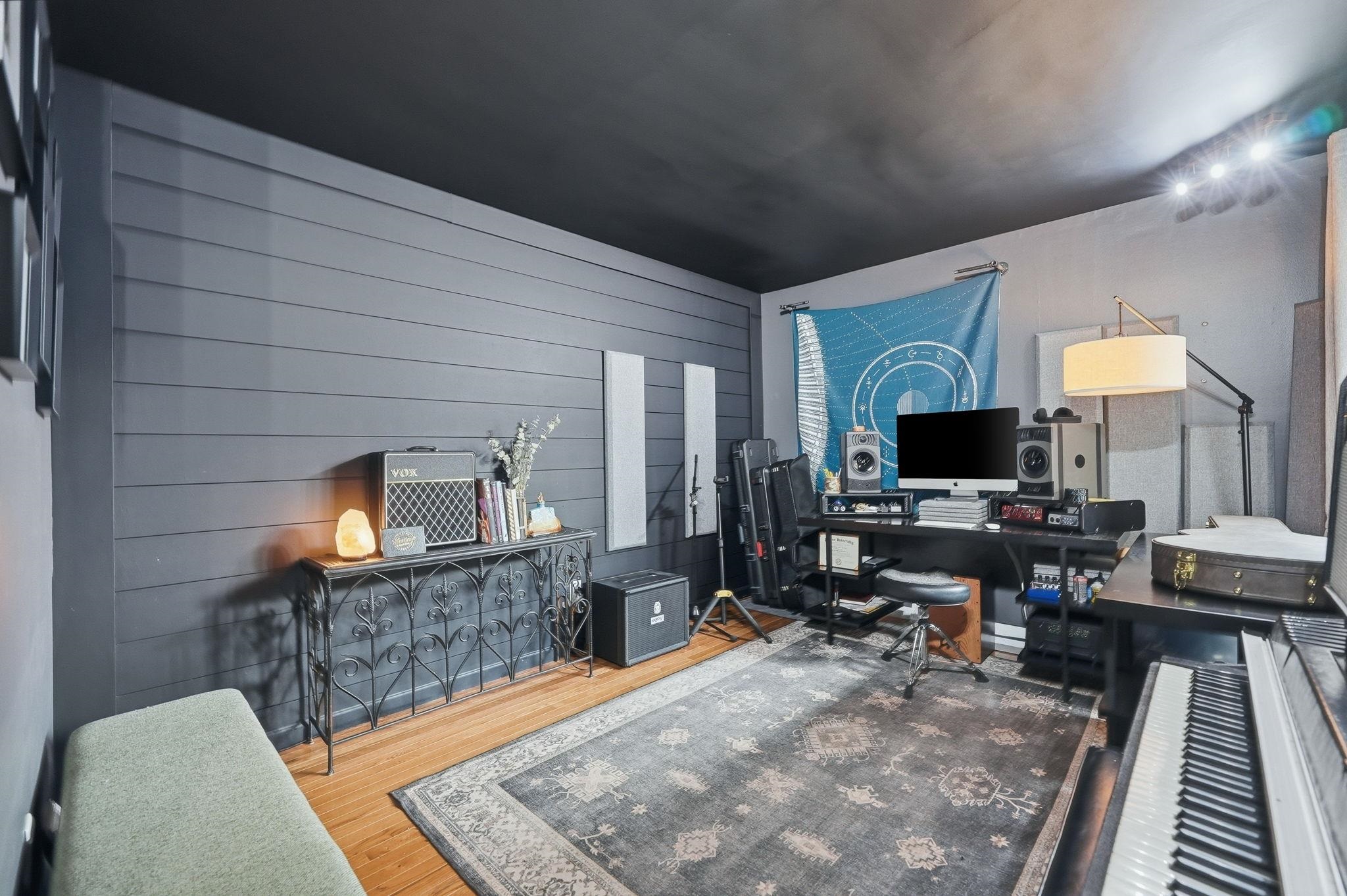 Room featuring wood-finish flooring, dark shiplap accent wall, recessed ceiling lighting, and a dark ceiling