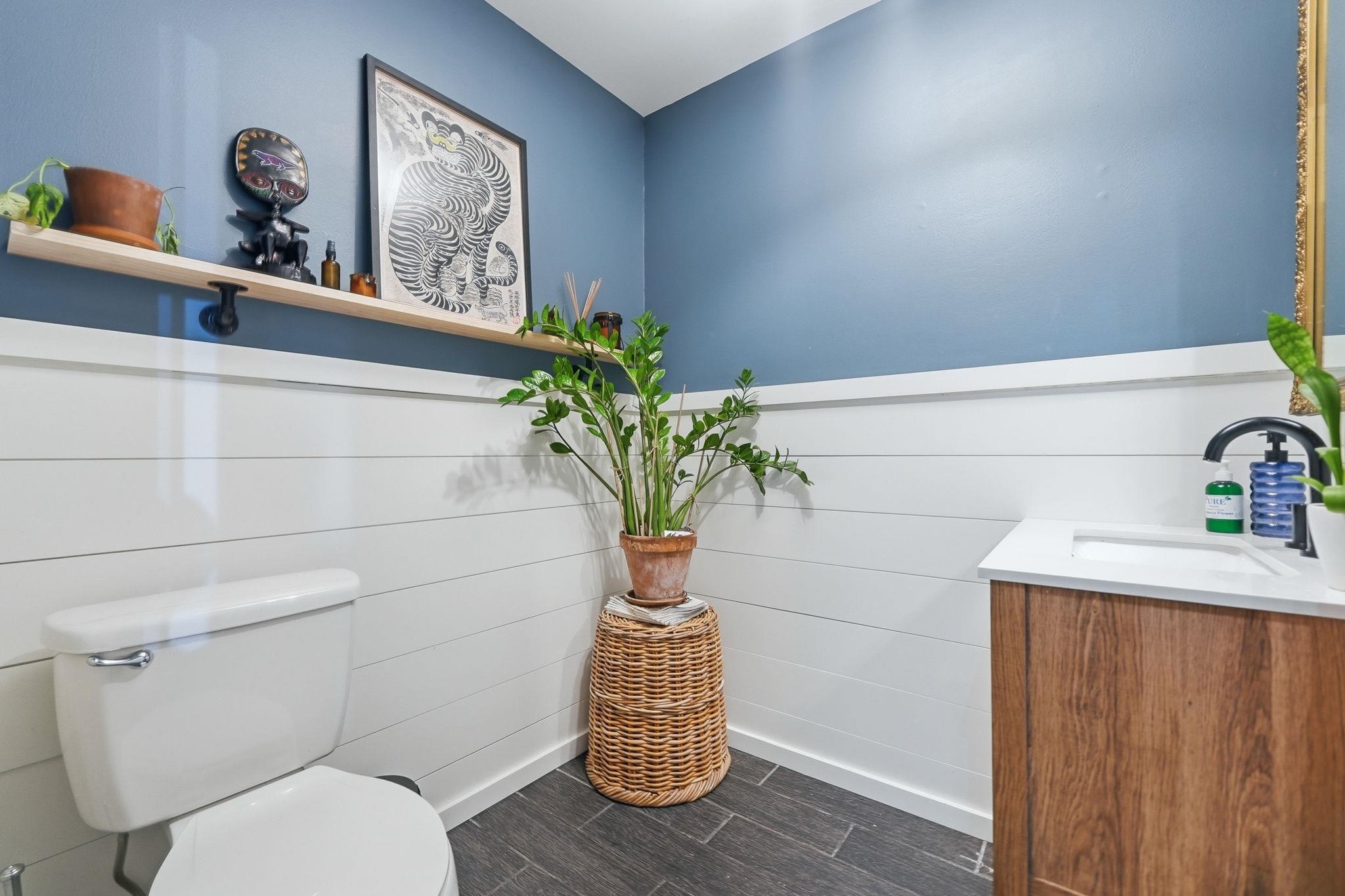 Powder room featuring a modern wood-finish vanity with a white countertop and integrated sink