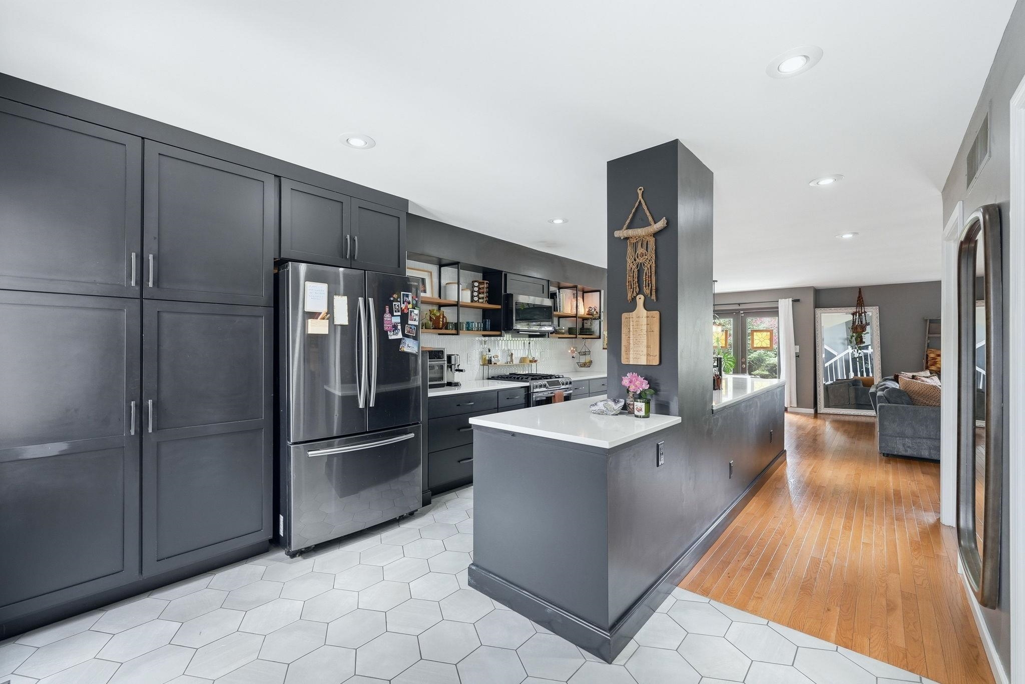 Kitchen featuring dark cabinetry, stainless steel appliances, white hexagonal tile flooring, white countertops, and recessed lighting