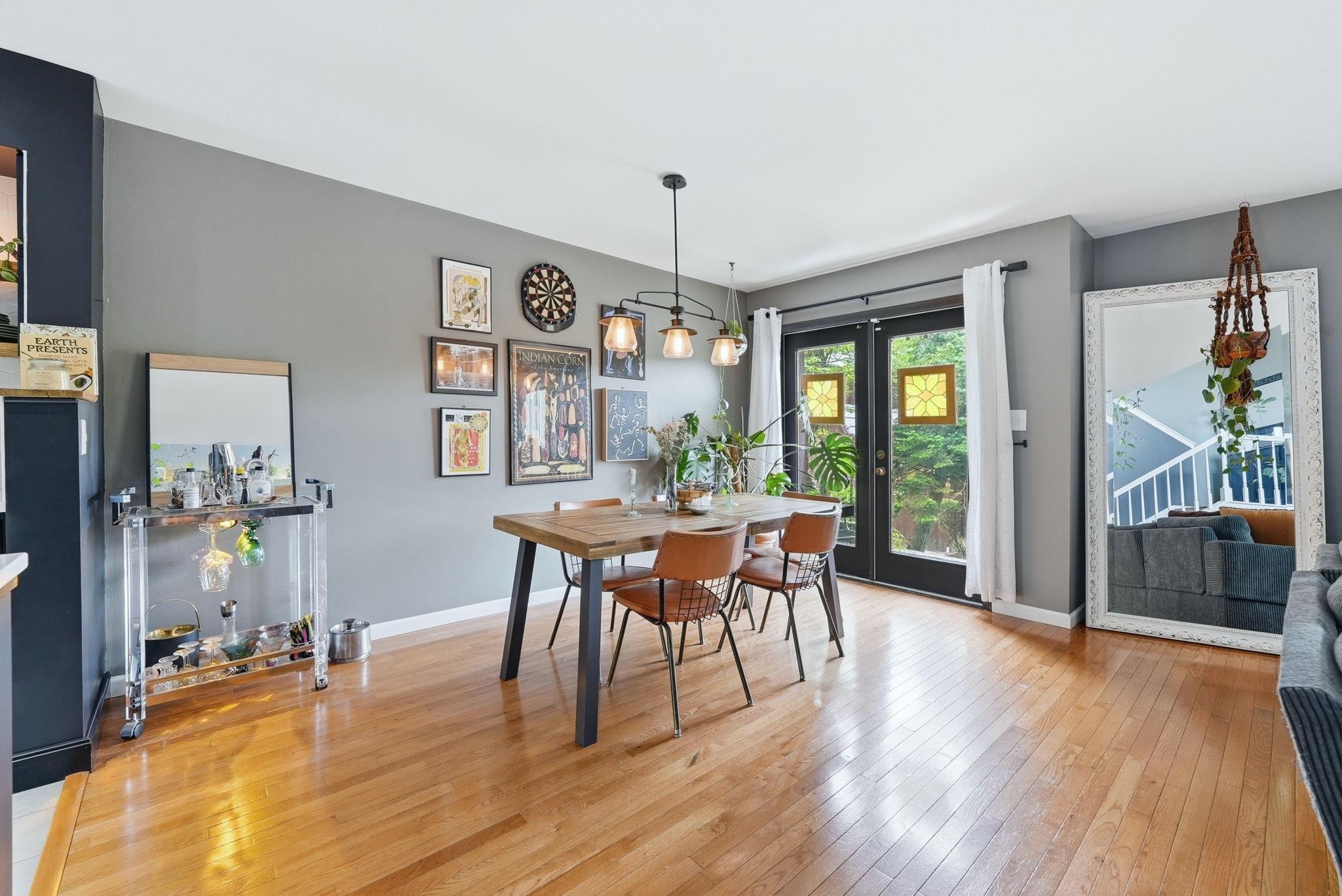 Dining area featuring wood-finish flooring and a contemporary linear chandelier