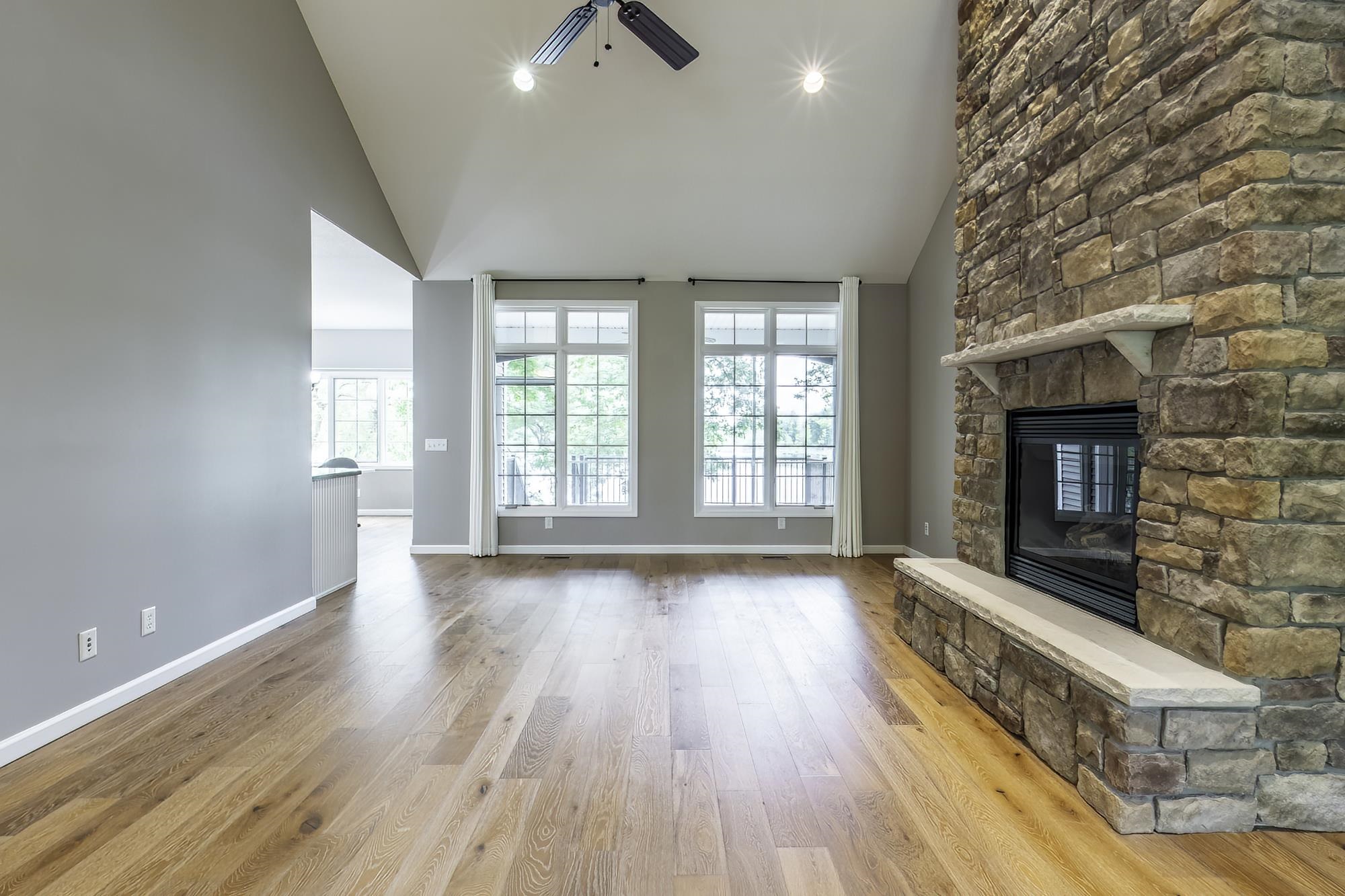 Great room featuring a floor-to-ceiling stone fireplace with a stone hearth and mantel