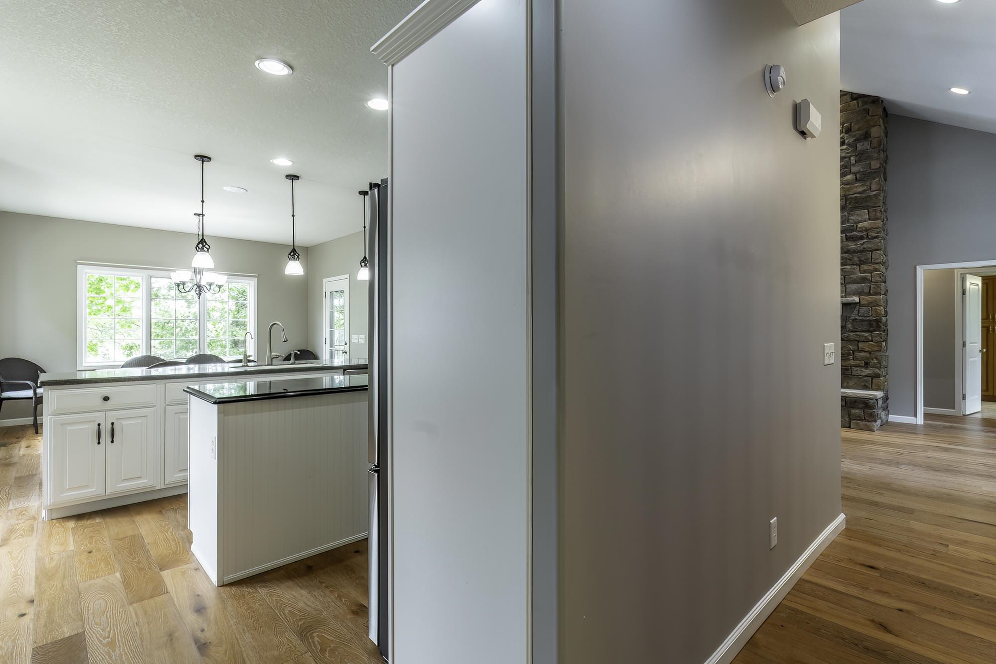 Kitchen featuring white cabinetry with dark hardware, dark countertops, a center island with beadboard paneling, and stainless steel appliances