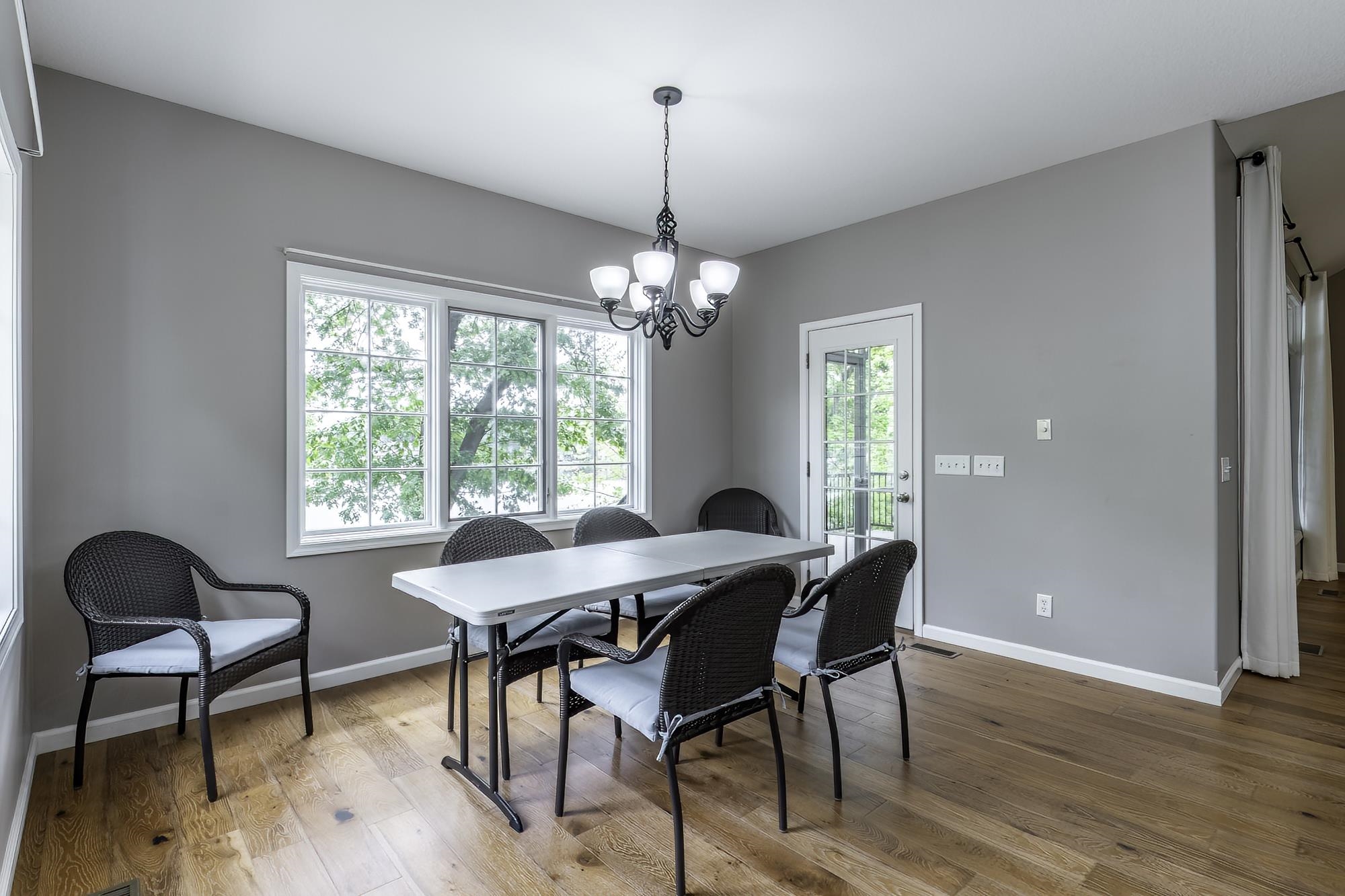 Dining area featuring wood-finish flooring, a multi-pane window, and a glass-paneled door