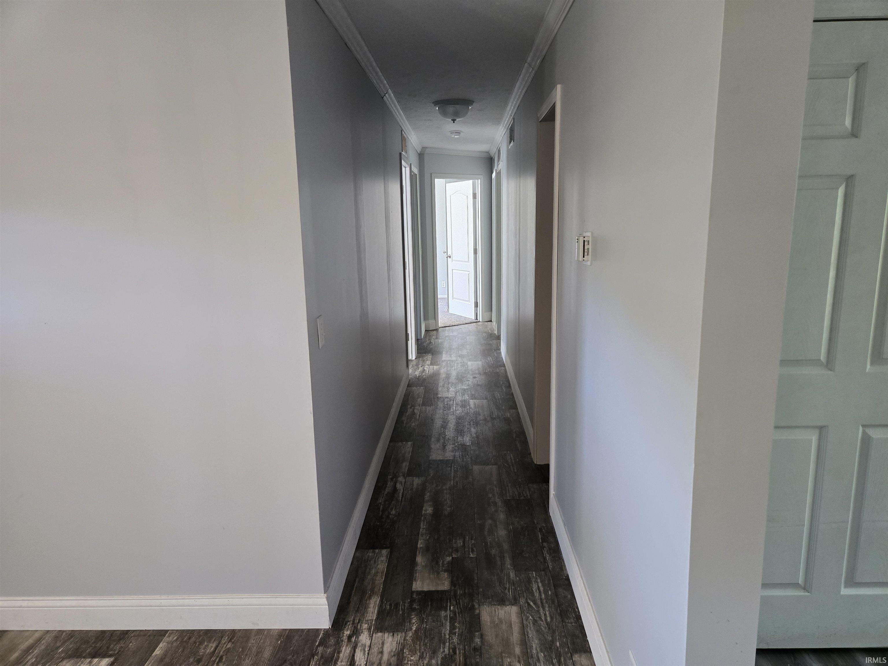 Interior hallway featuring wood-finish flooring and light-toned wall paint
