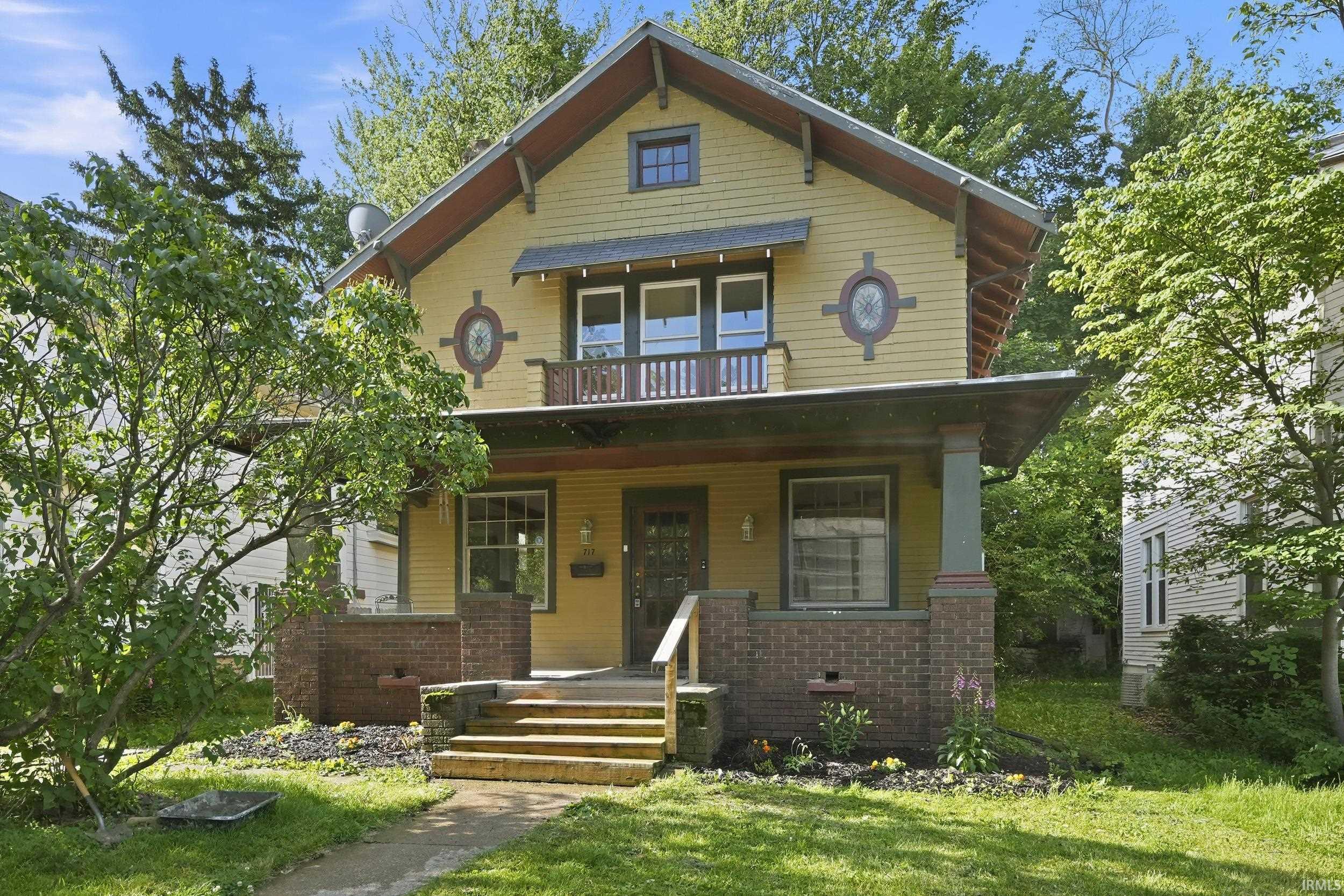 Craftsman-style exterior featuring yellow siding and contrasting trim