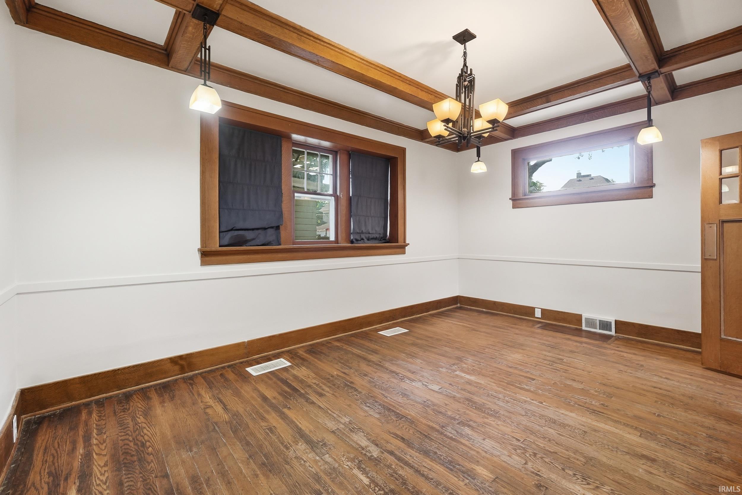 Exposed wood-beam ceilings complement wood-finish flooring throughout this room