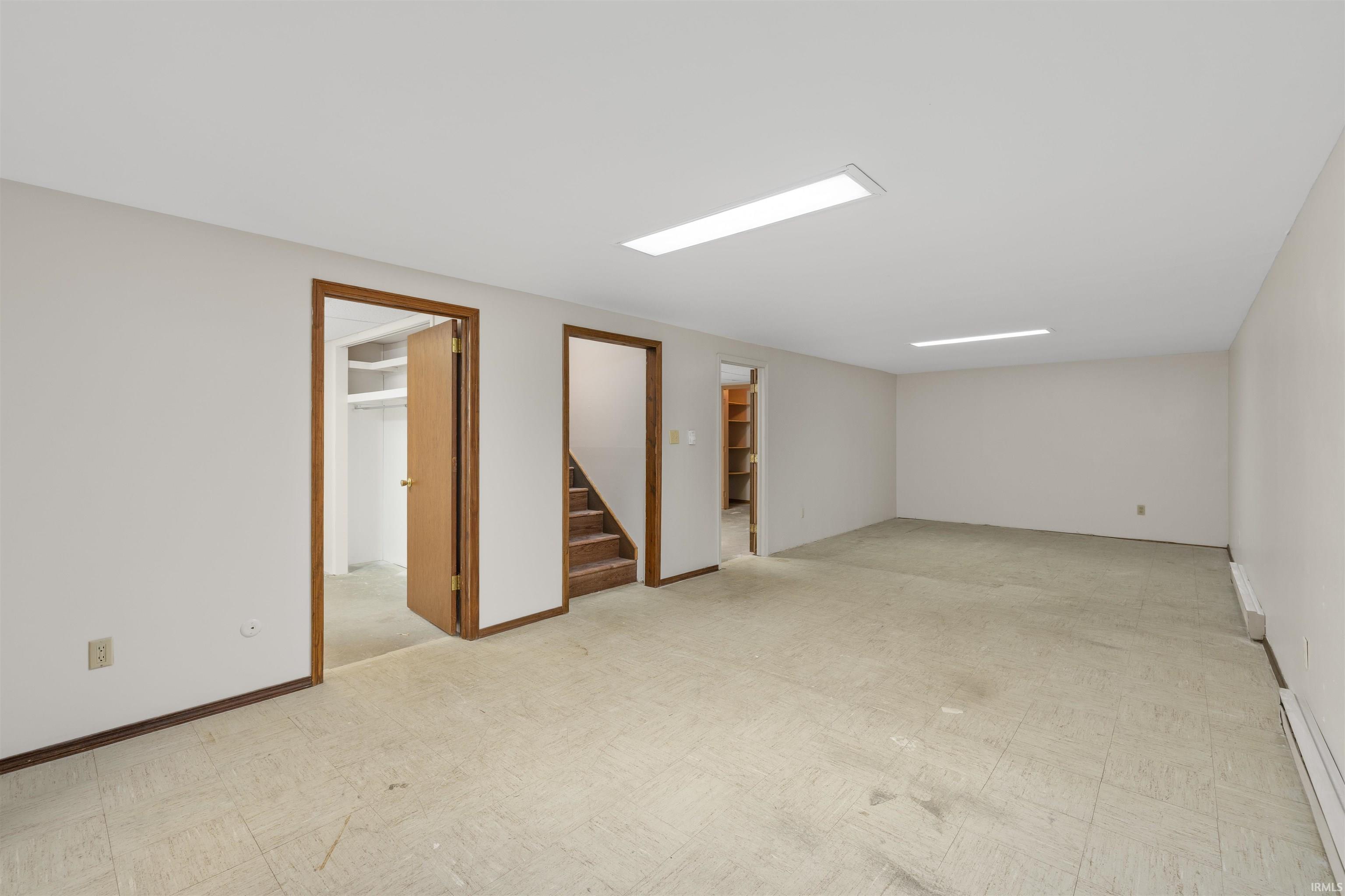Spacious room featuring neutral walls, recessed lighting, and a beige floor