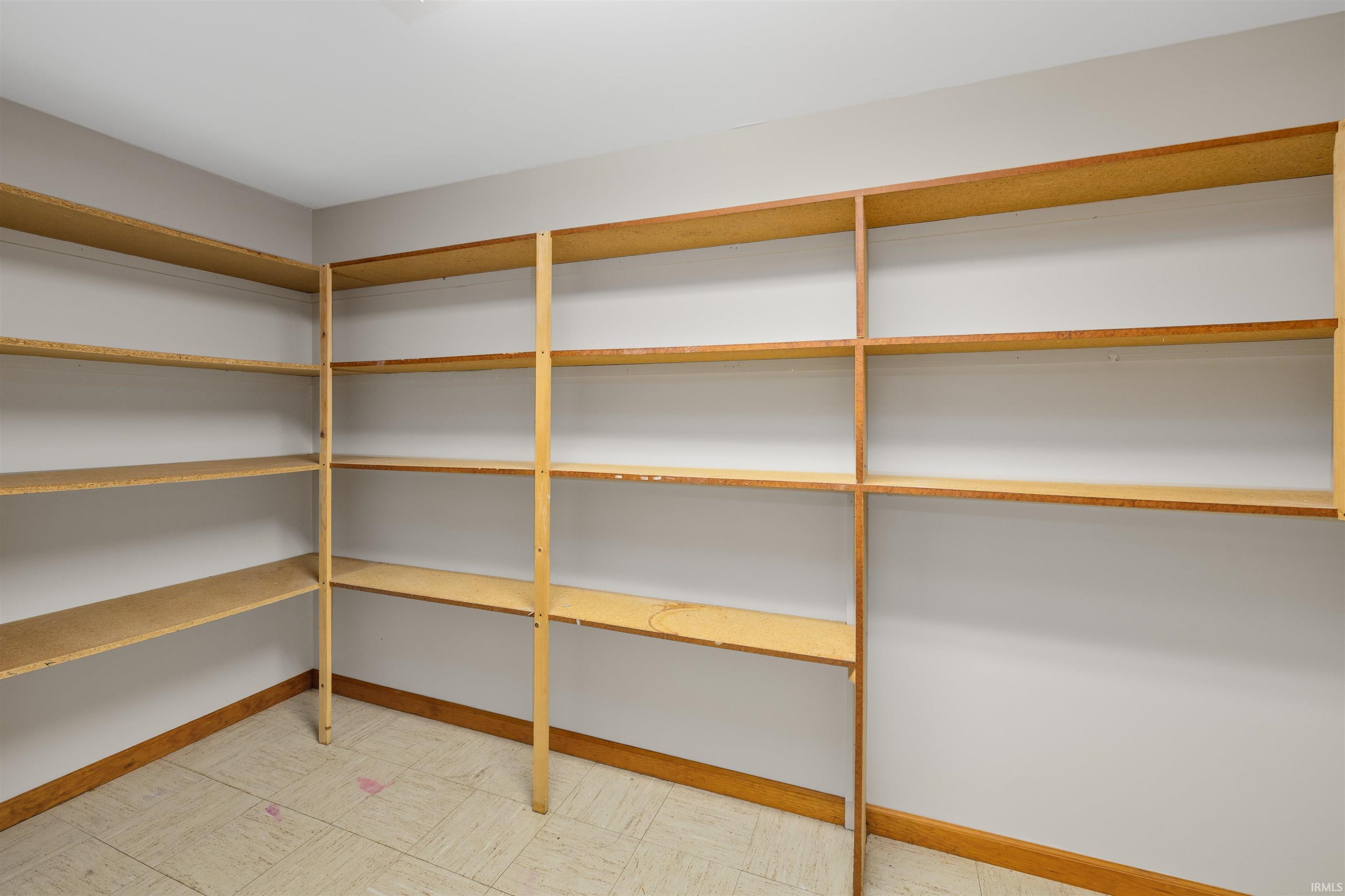 Built-in wood-finish shelving with multiple tiers, set against light-toned walls and complemented by wood-finish baseboards