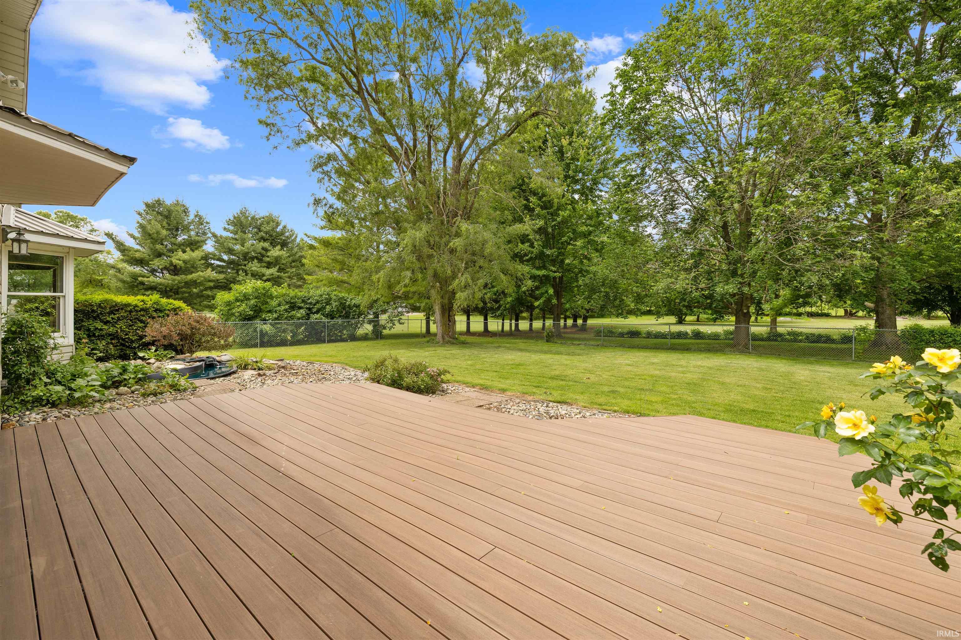 Expansive outdoor deck with wood-finish planks, providing ample space for outdoor living