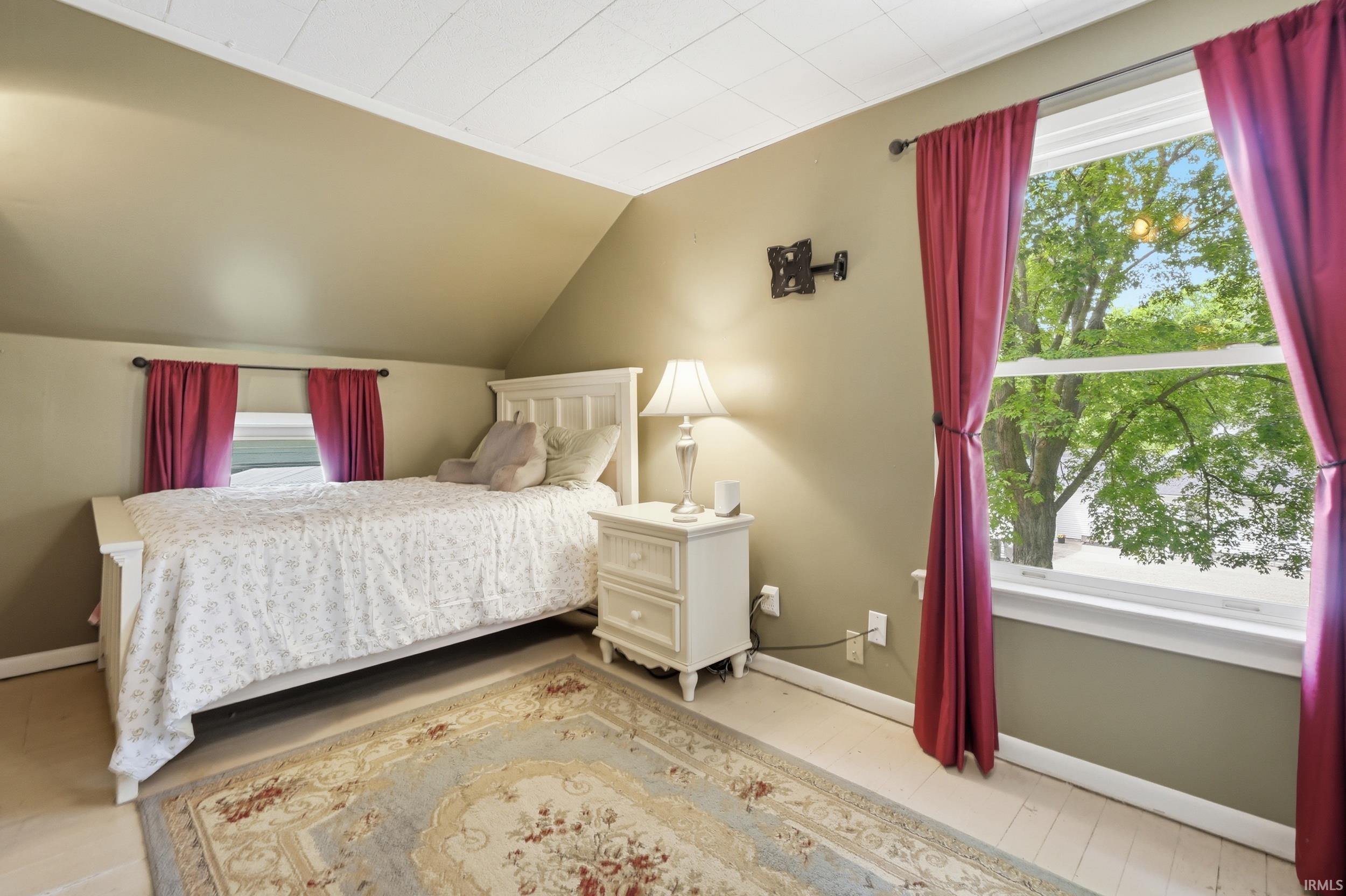 Bedroom featuring sloped ceilings and light-toned walls