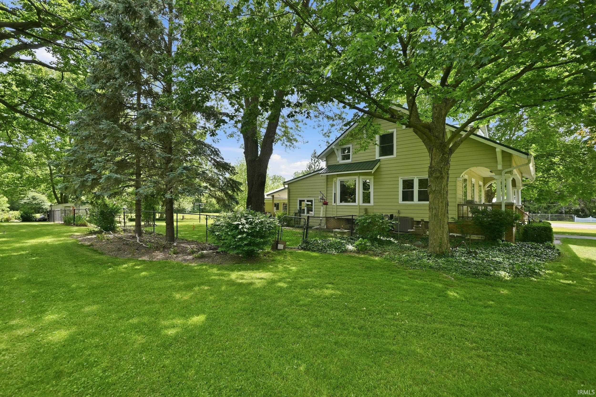 Spacious lawn area with mature trees and established landscaping