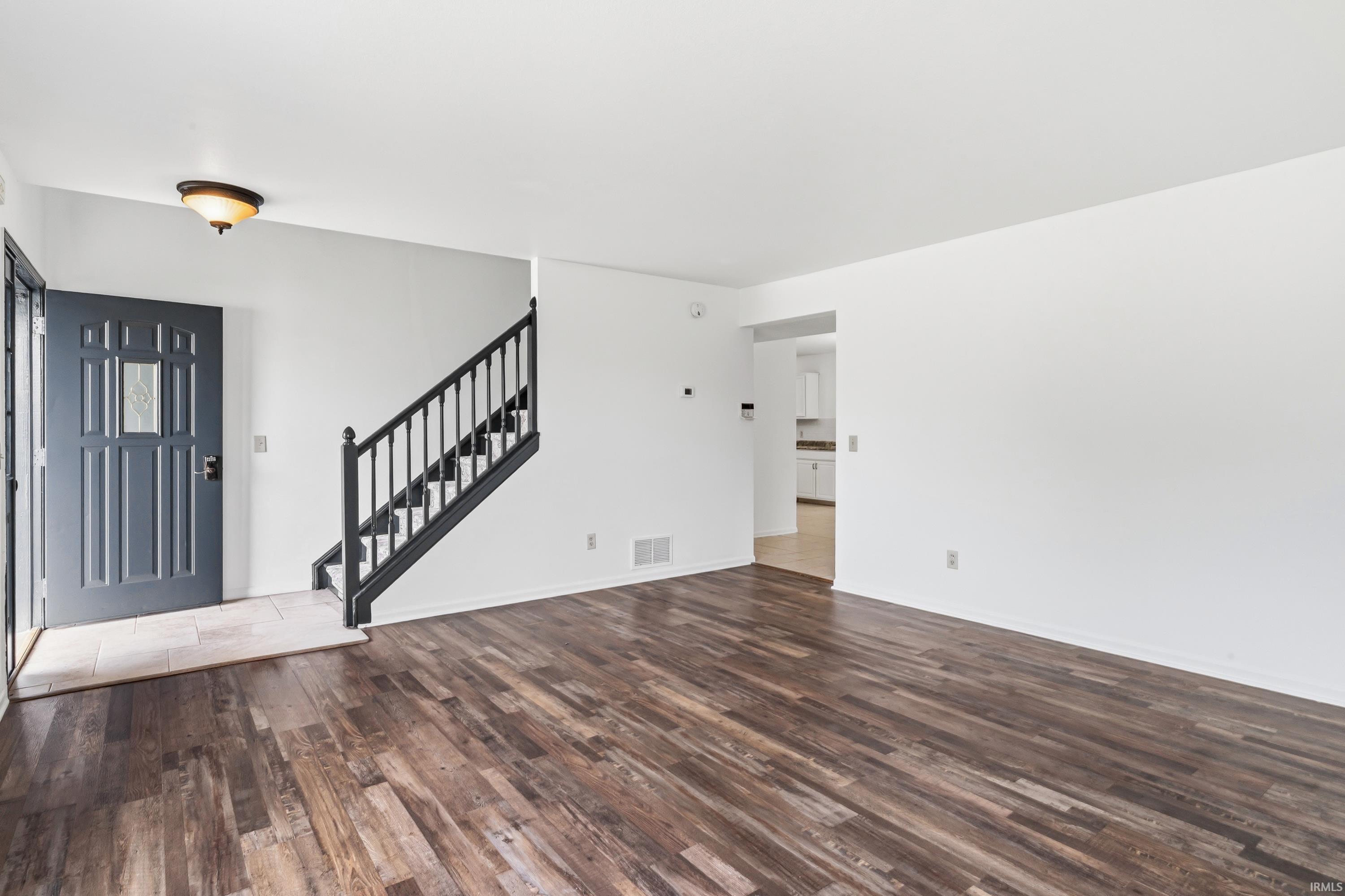 Entryway featuring a dark paneled door with glass insert, tile flooring, and a semi-flush mount light fixture