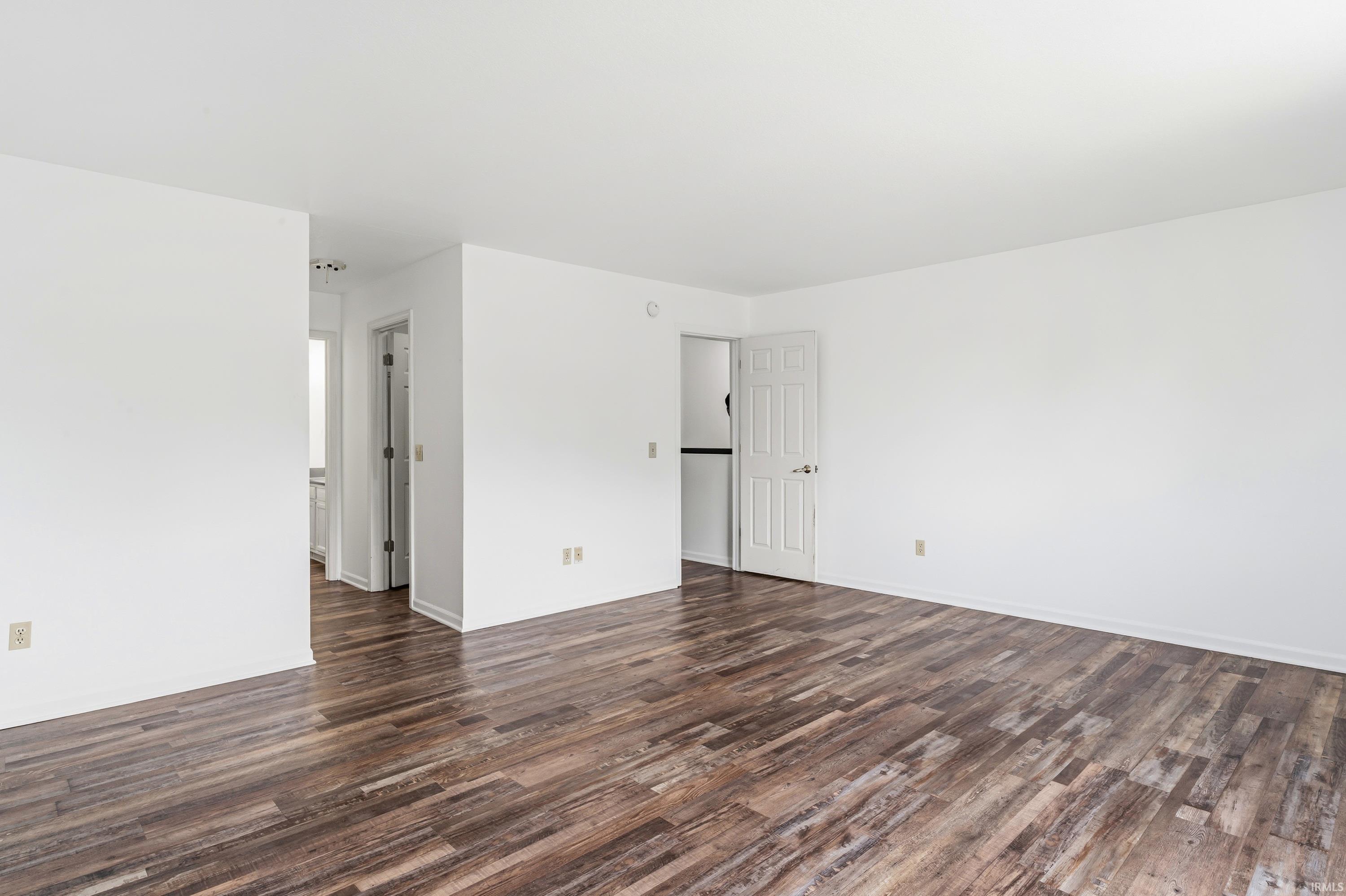 Spacious interior featuring wood-finish flooring and bright white walls