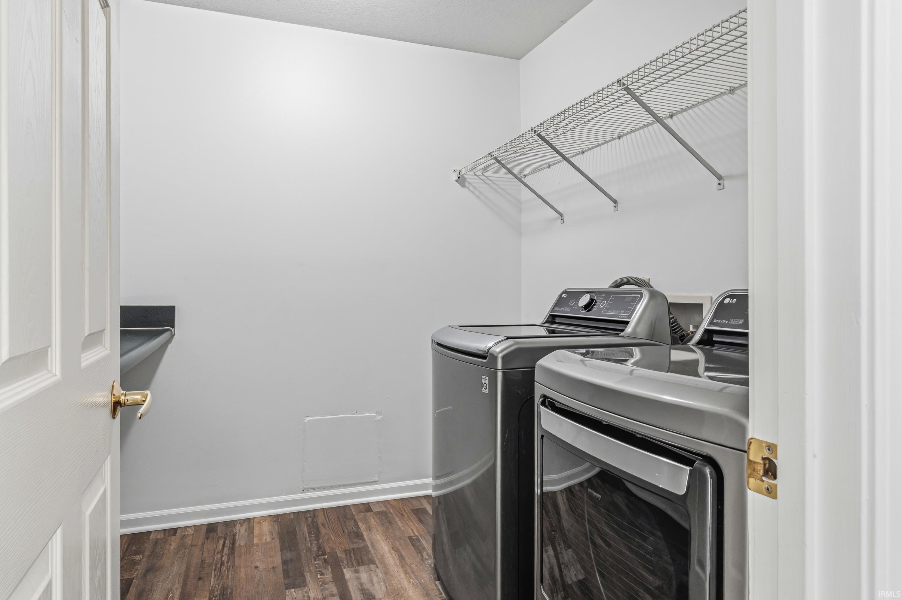 Dedicated laundry area featuring a wire shelving unit, wood-finish flooring, and a countertop