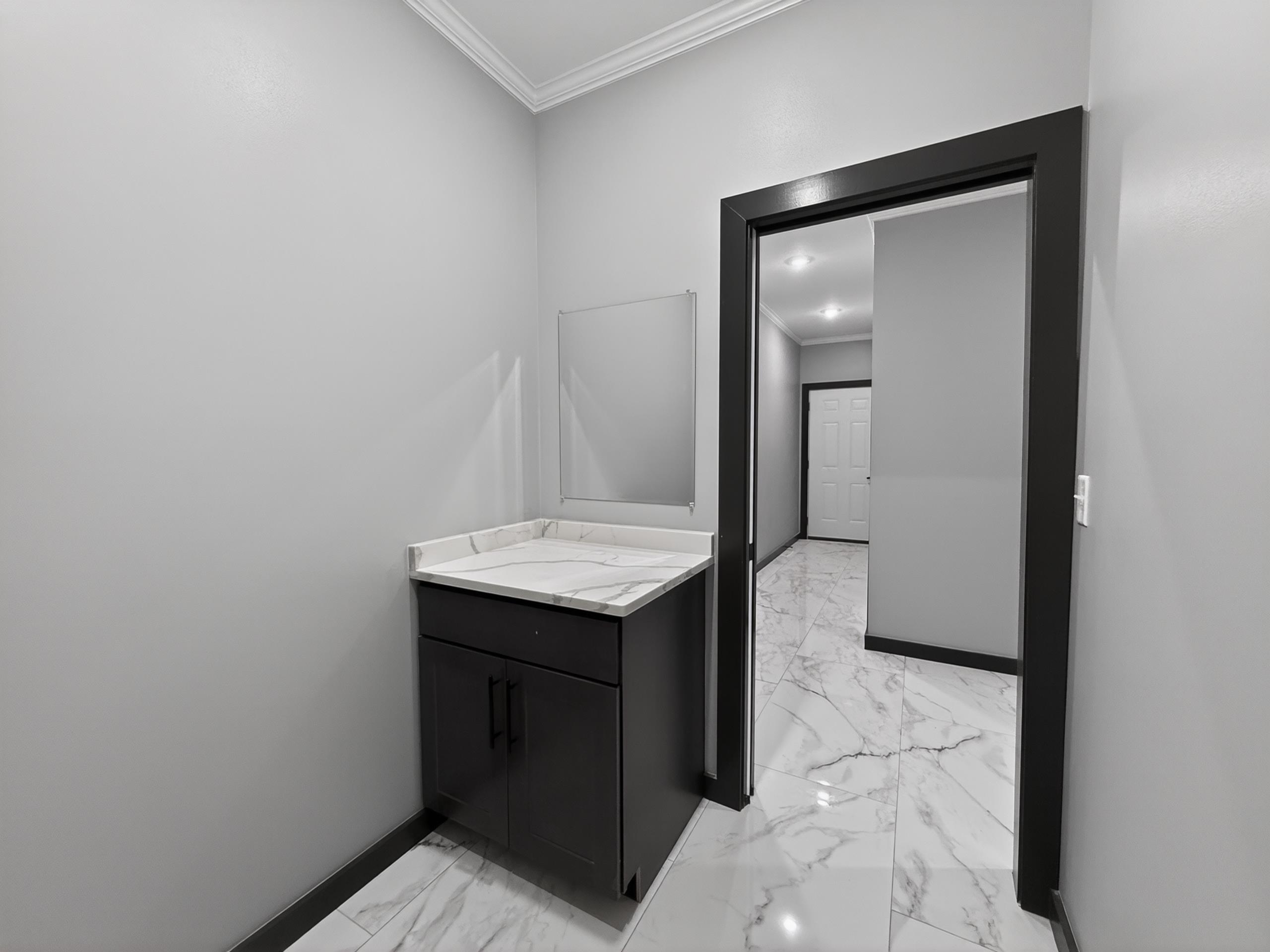 Modern vanity with a light-colored countertop and dark cabinetry