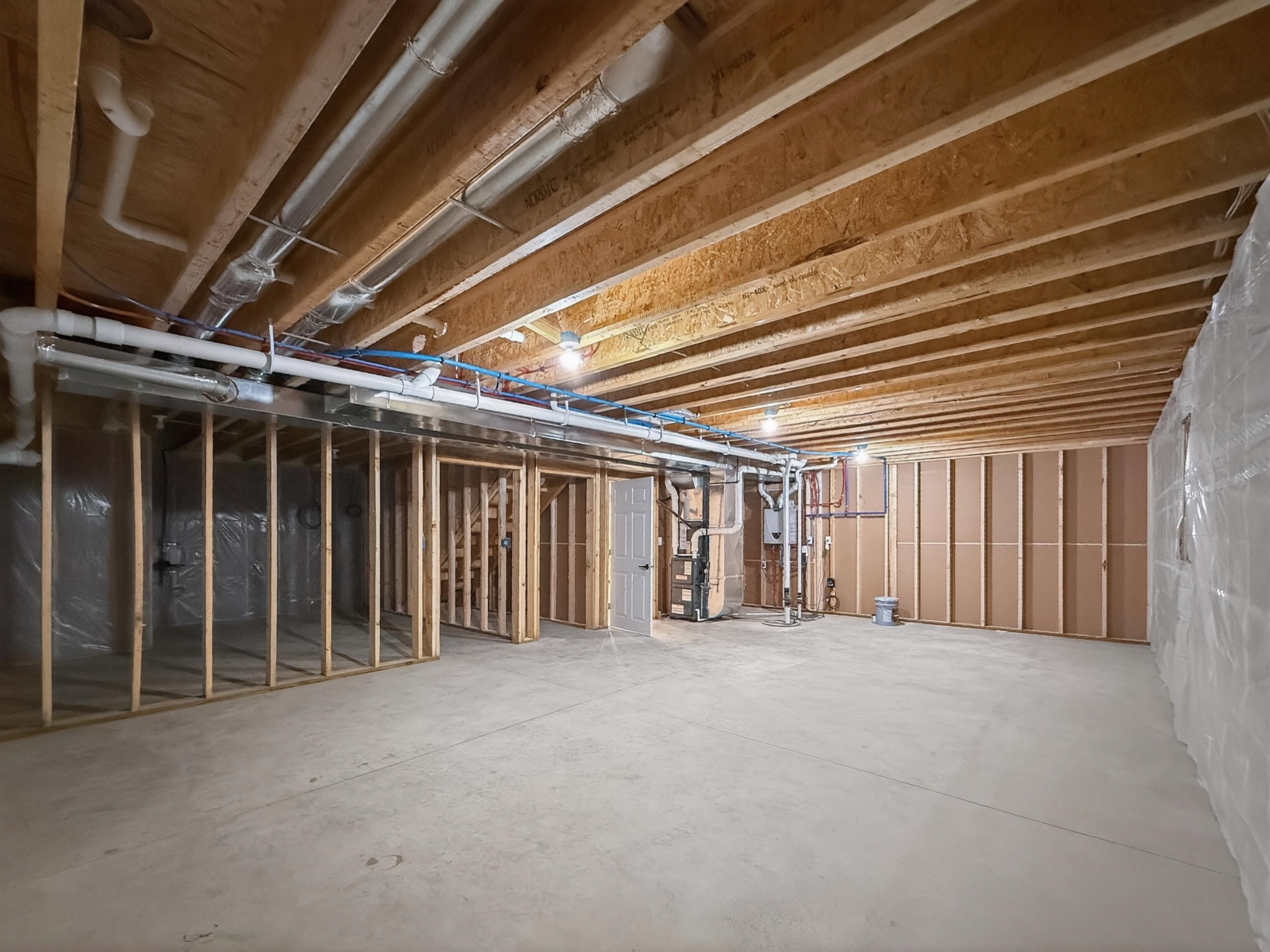 Unfinished basement space featuring exposed wood joists and concrete flooring