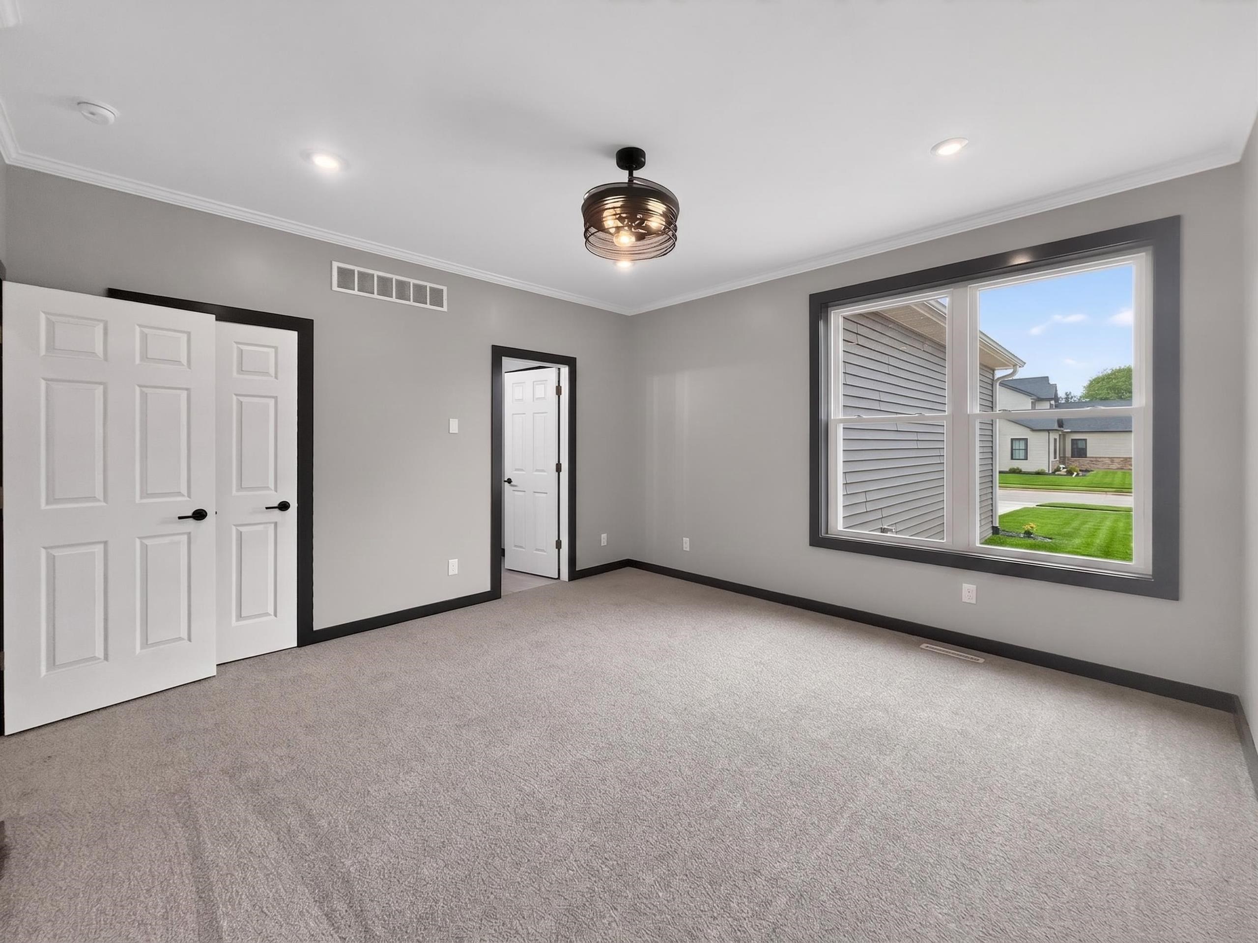 Gray-toned room featuring a large window with dark trim, recessed lighting, and a contemporary ceiling fixture