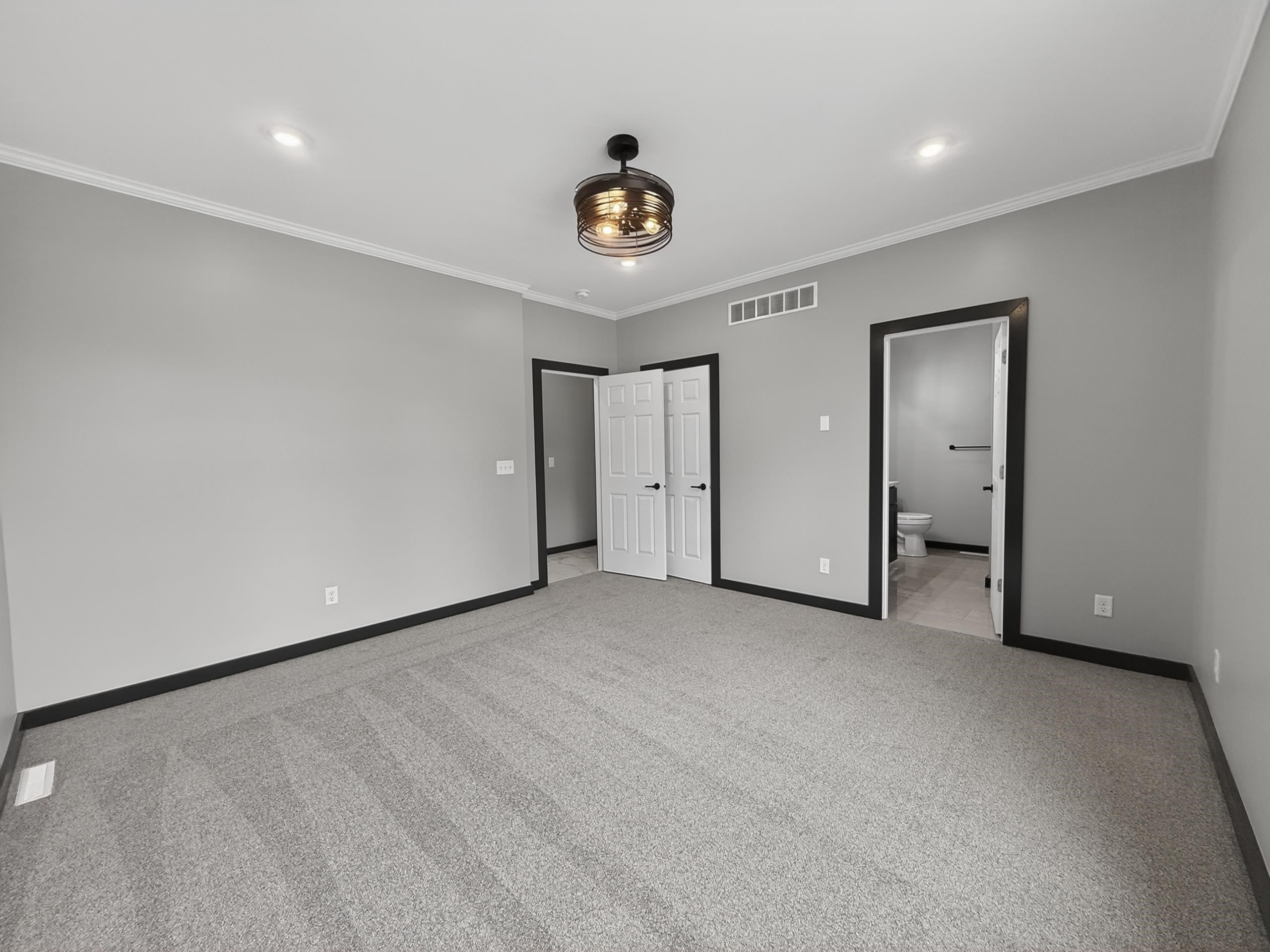 Spacious carpeted room featuring a ceiling fan with integrated lighting, recessed ceiling lights, and two panel doors