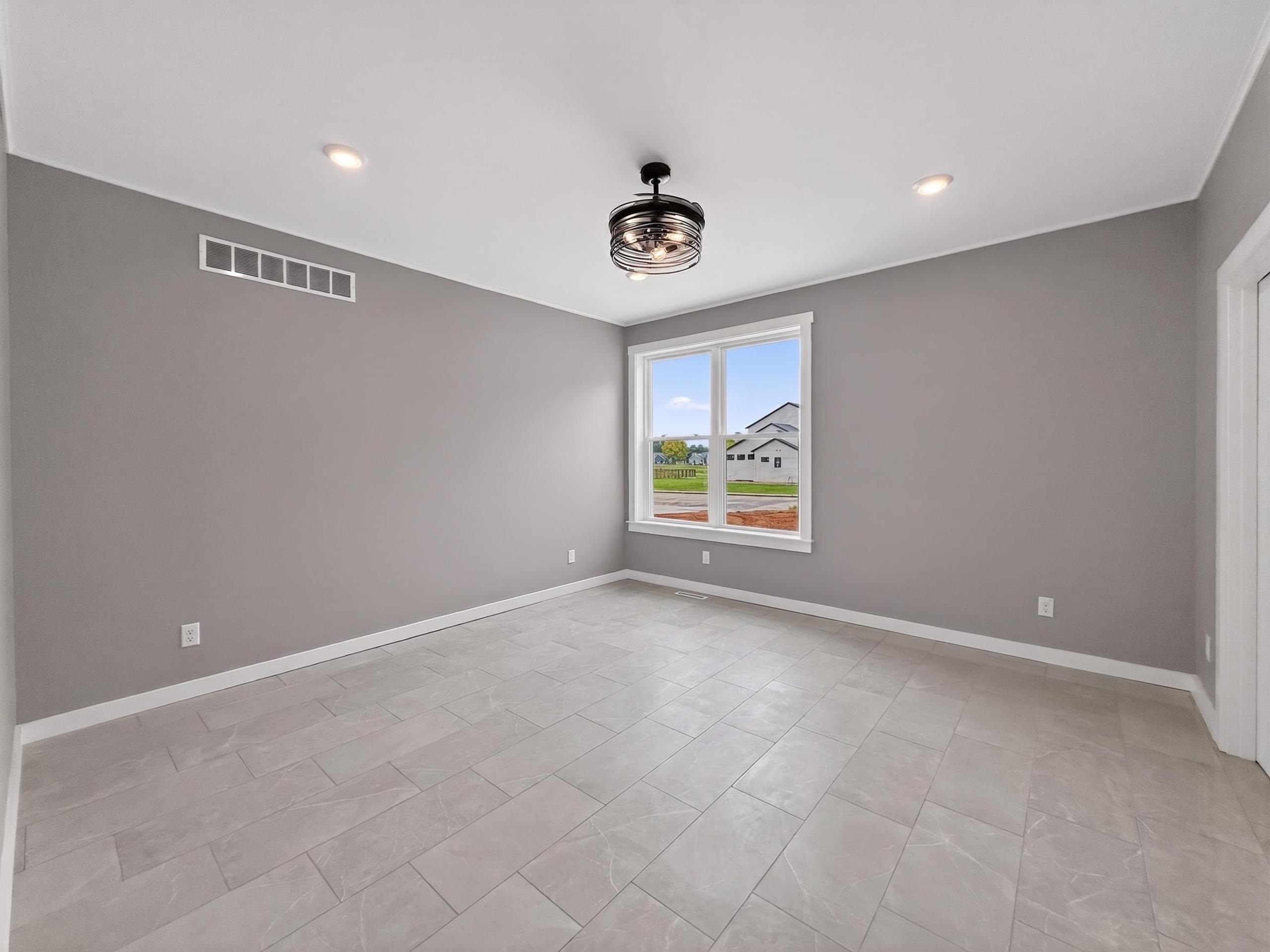Spacious room featuring large format tile flooring, a modern drum chandelier, recessed lighting, and a prominent window with white trim