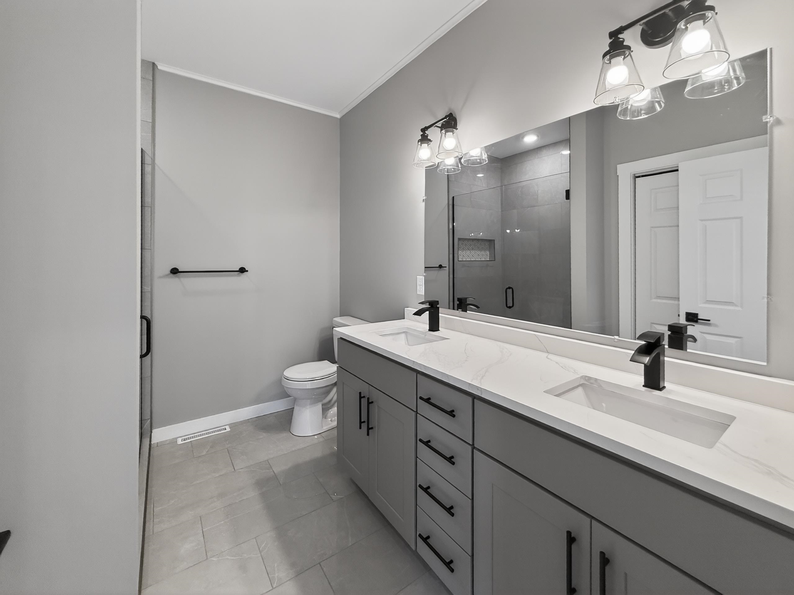 Dual vanity with stone-finish countertop, undermount sinks, and matte black fixtures
