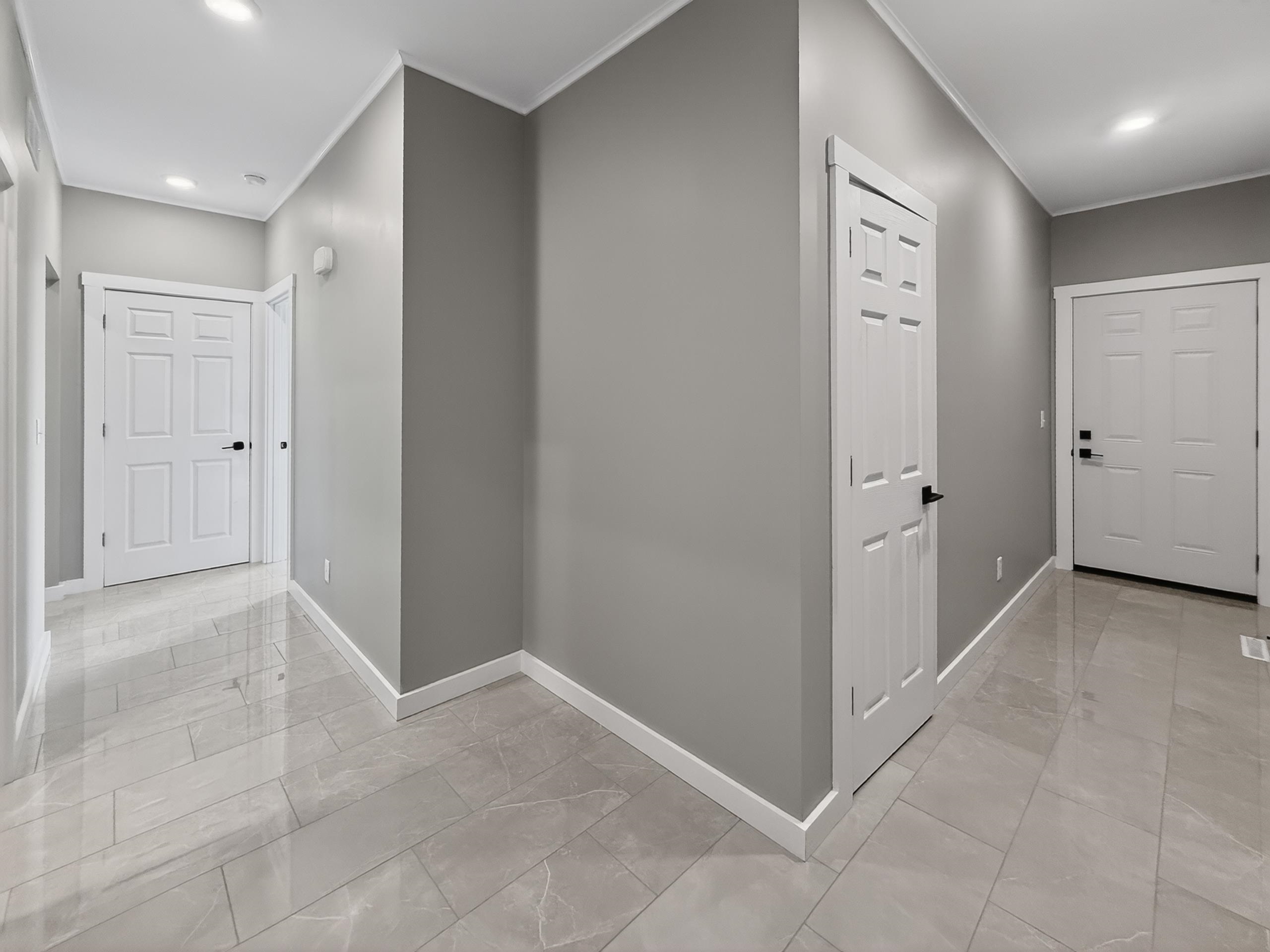 Hallway featuring recessed lighting, light gray wall paint, and white trim