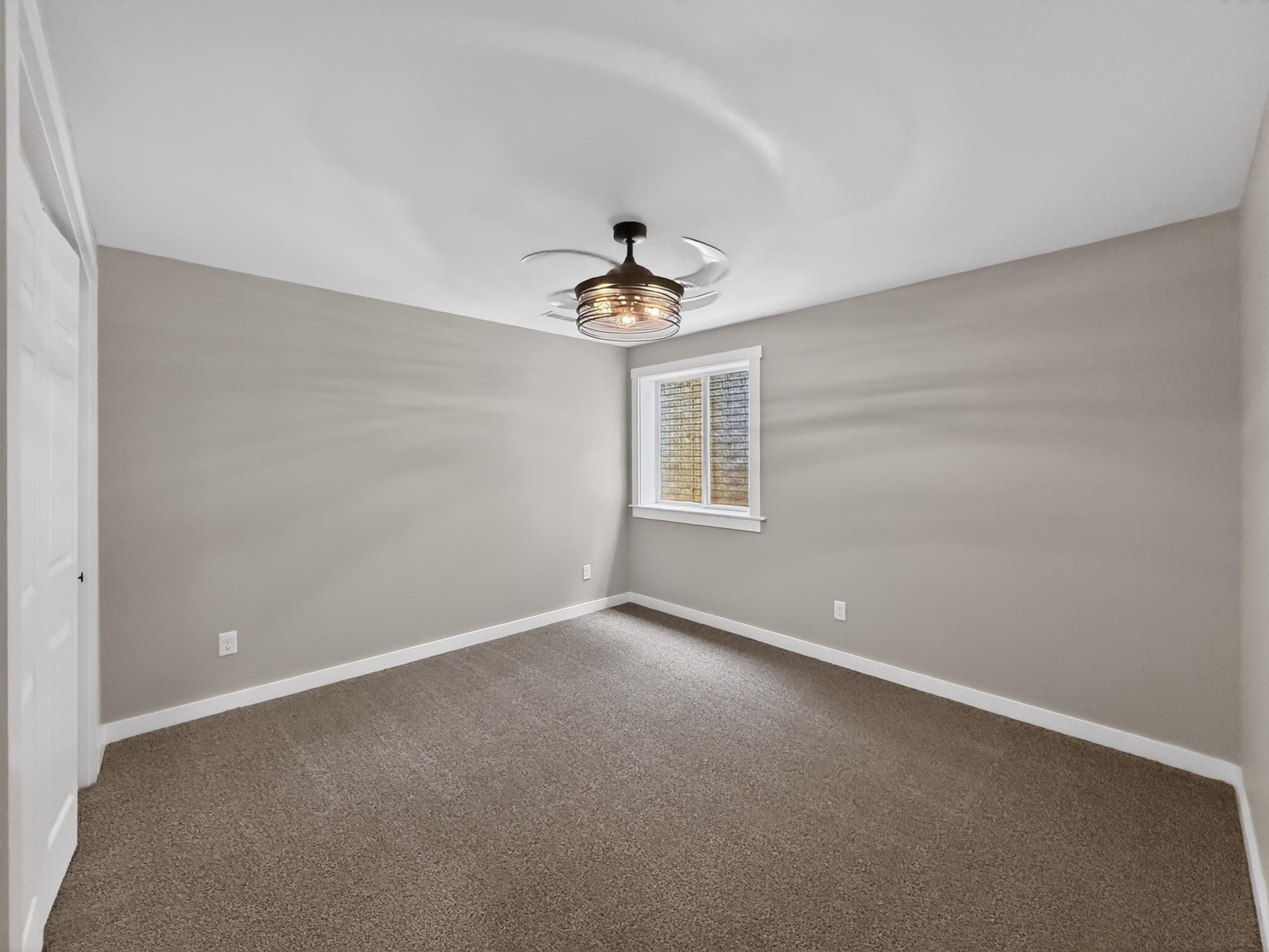 Neutral-toned room featuring light gray walls, white trim, and brown carpet flooring