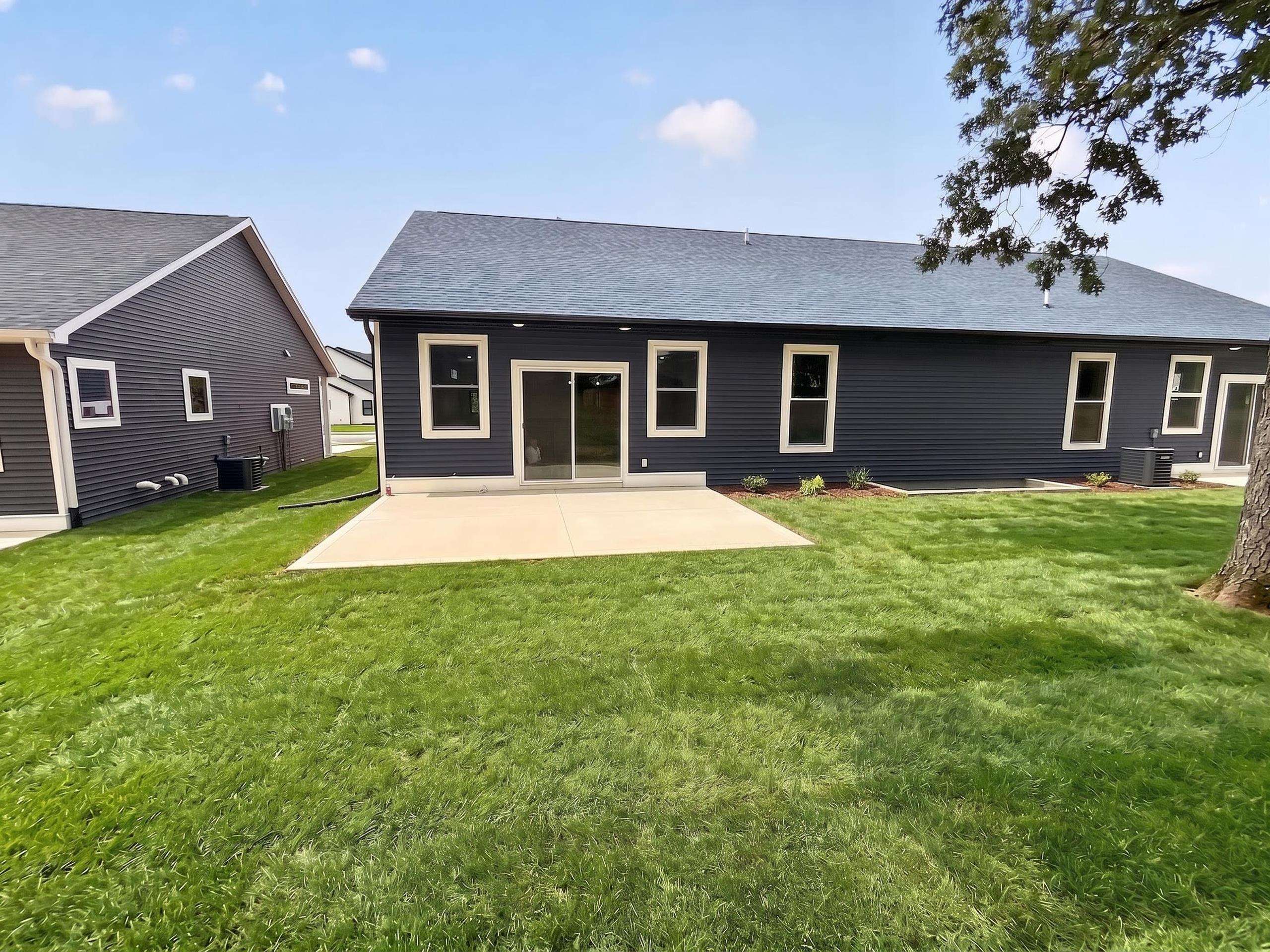 Expansive green lawn with a concrete patio