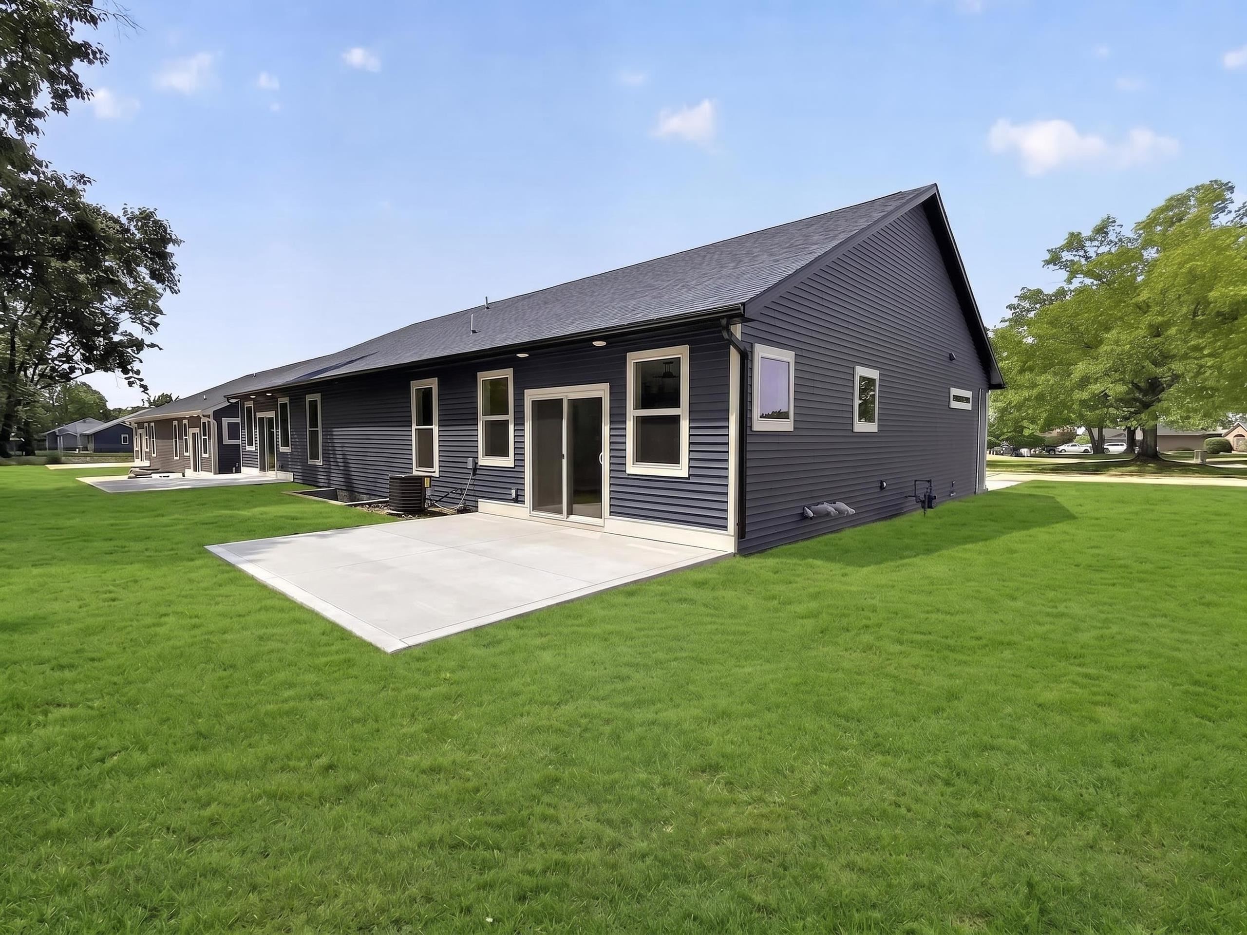 Modern exterior featuring dark gray horizontal siding, a gabled roofline, and white trim windows
