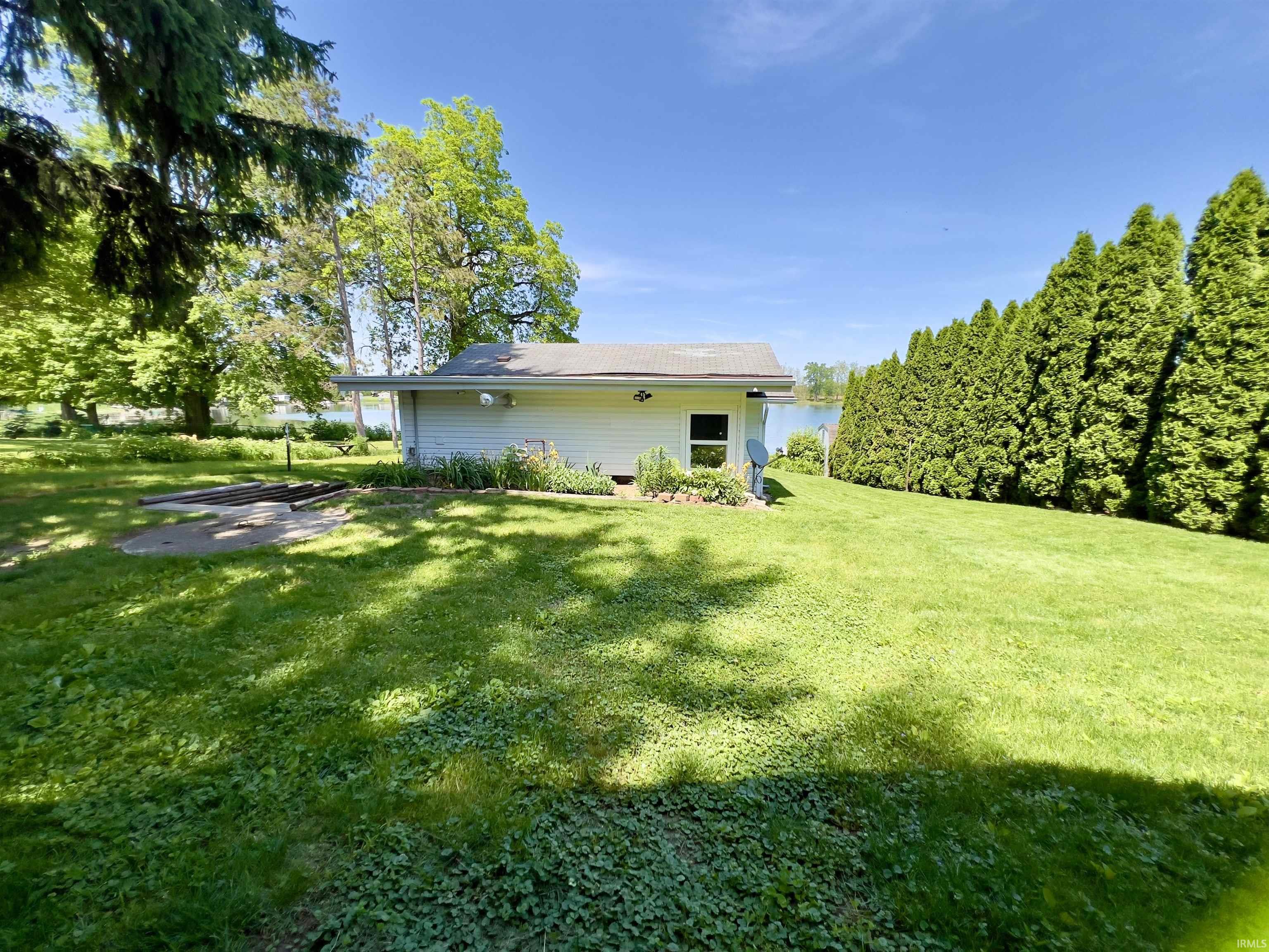 Expansive rear yard featuring green lawn and mature trees