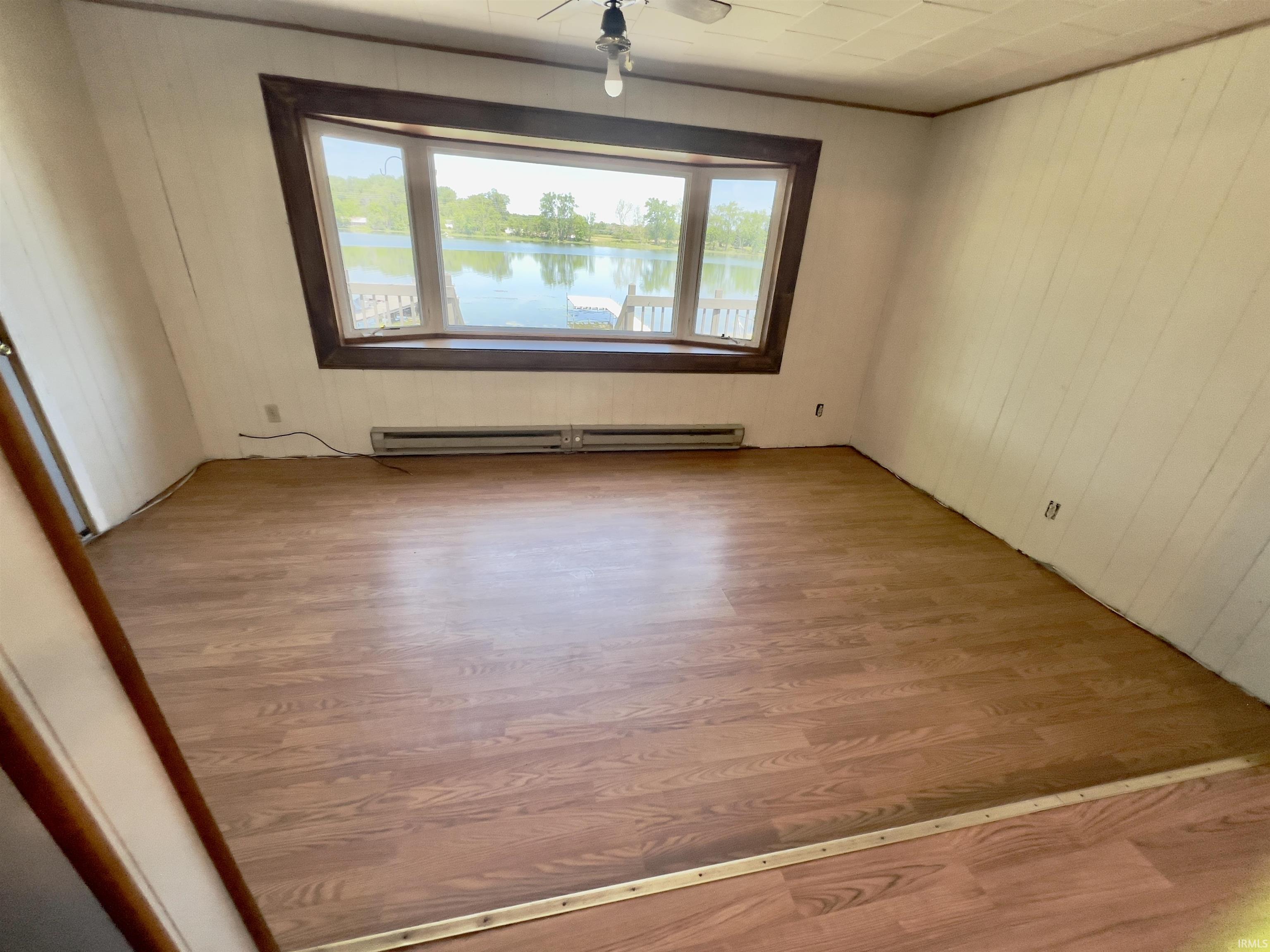 Expansive bay window framing waterfront scenery with wood-finish flooring