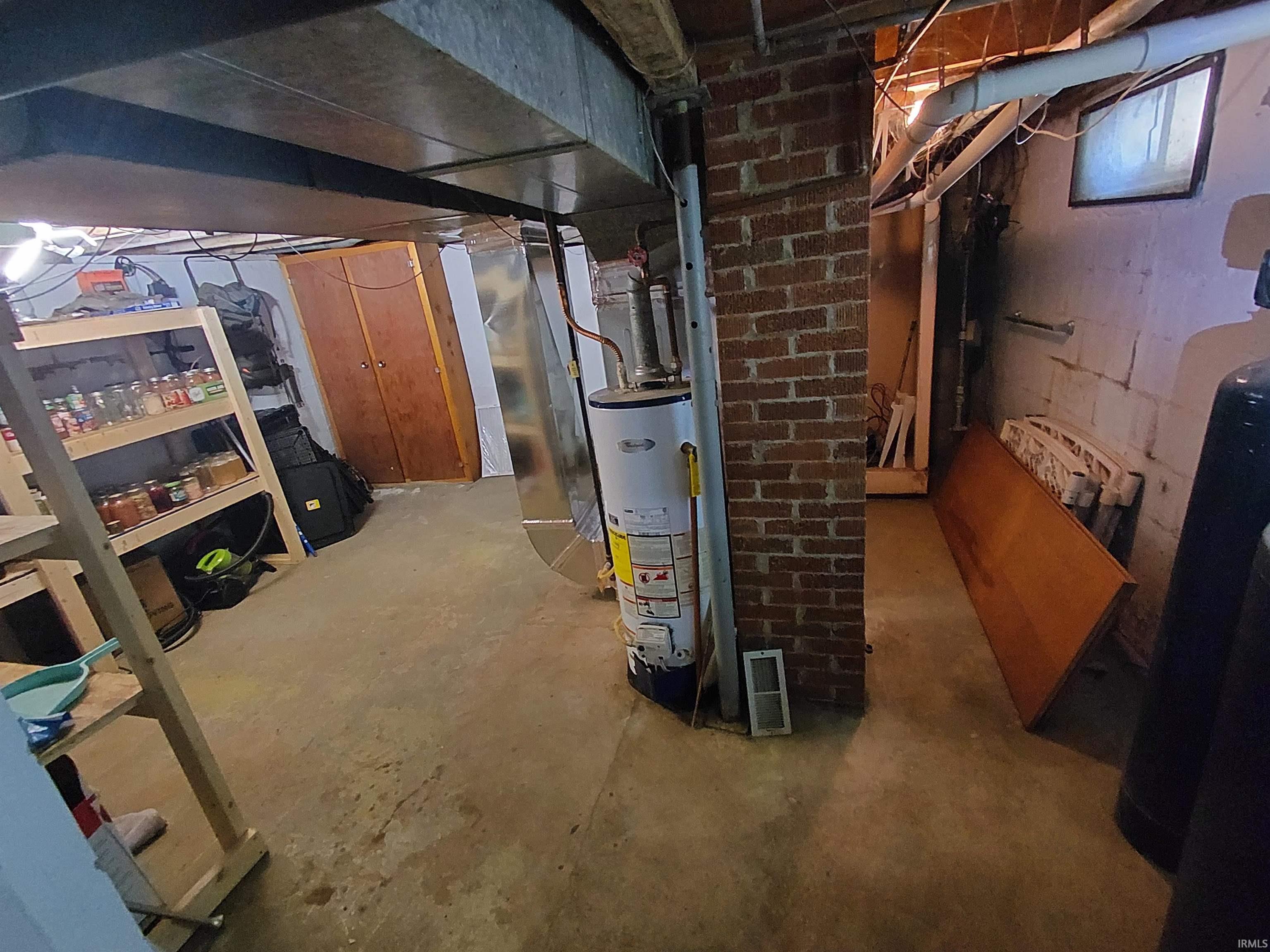 Exposed brick support column, concrete flooring, and visible ductwork