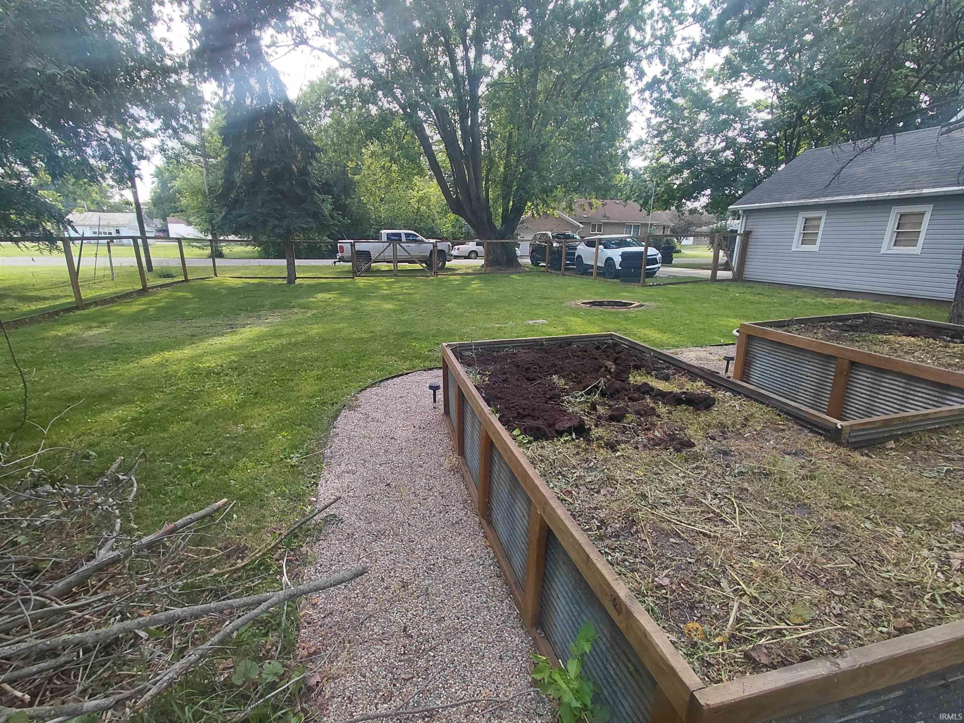 Backyard featuring two raised garden beds with wood framing and corrugated metal siding