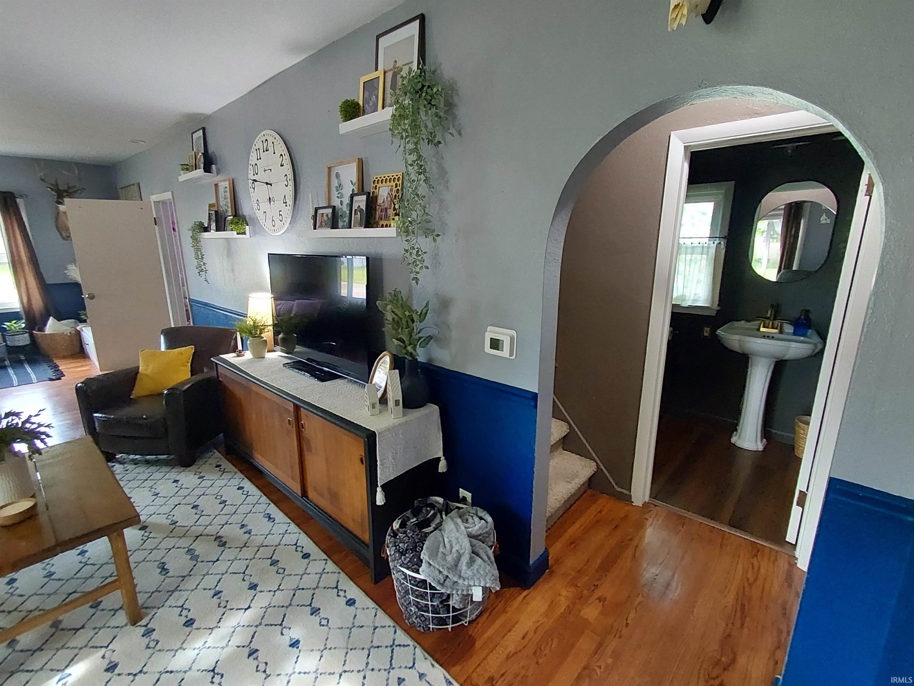 Hardwood-style flooring throughout the main living area, featuring a two-tone wall treatment with a vibrant blue wainscoting