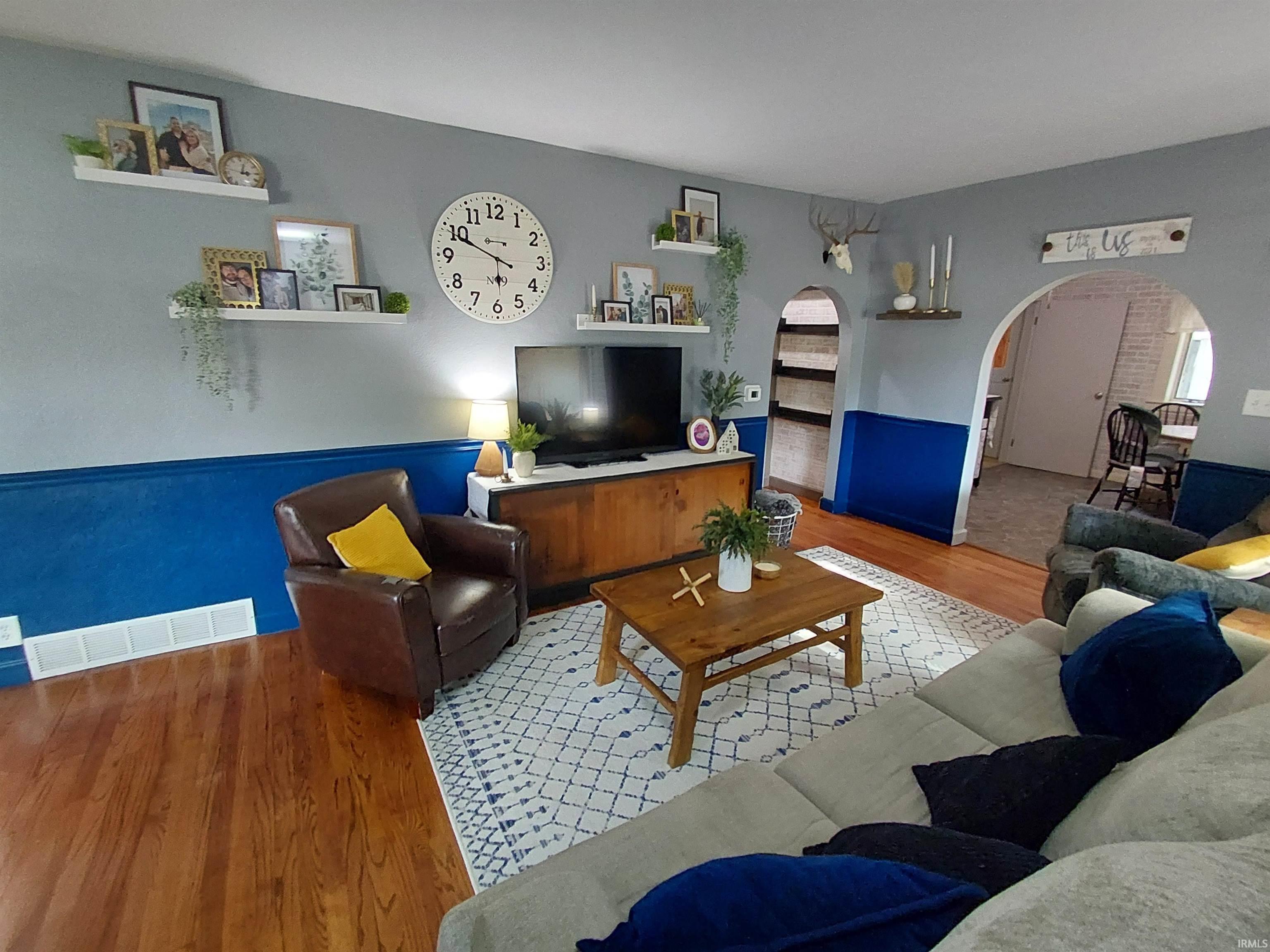 Living area featuring wood-finish flooring, two-toned wall paint, and recessed shelving