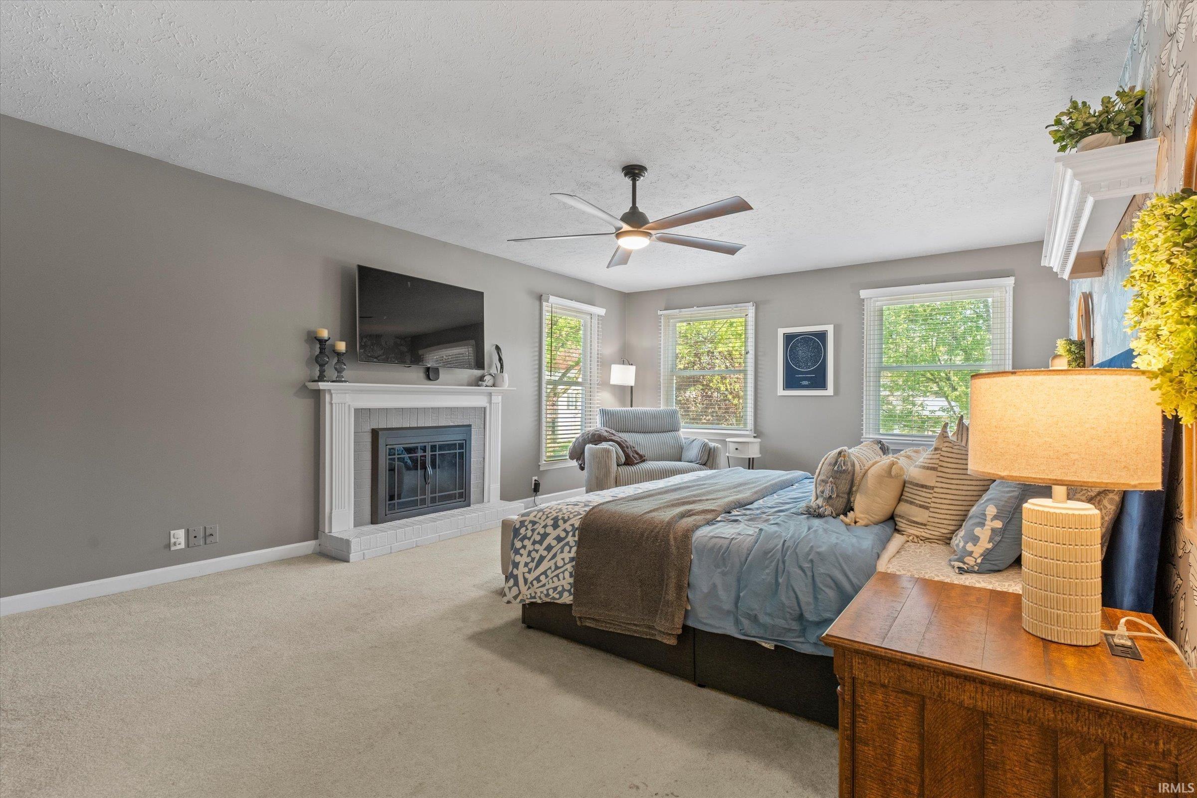Carpeted room featuring a fireplace with a white mantel and tile surround
