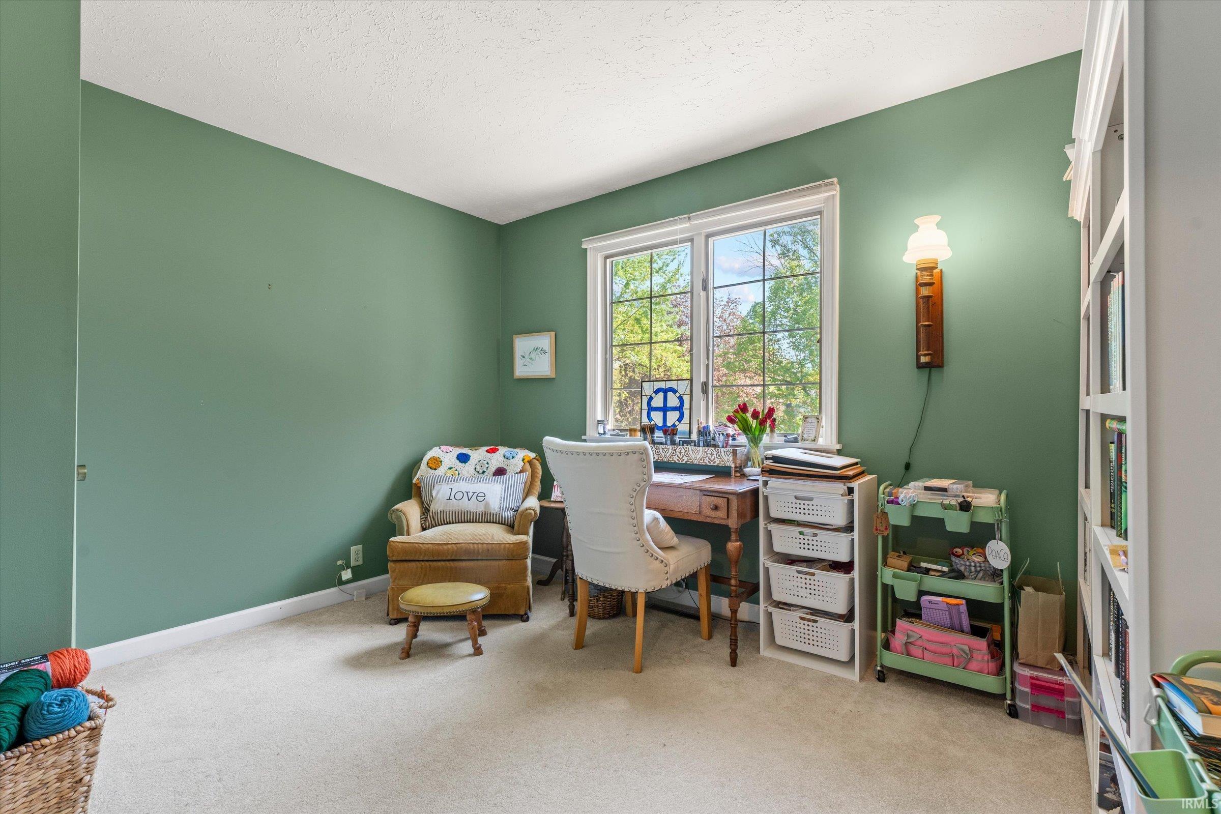 Room featuring a large window, a built-in wall sconce, and a full-height built-in bookshelf