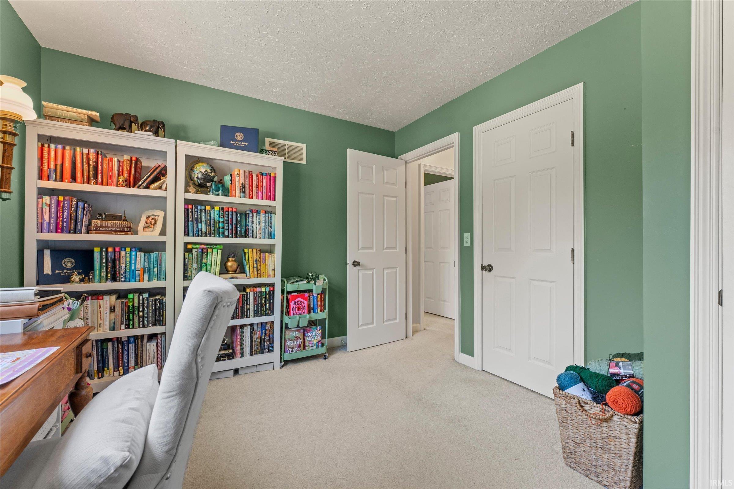 Room featuring soft green walls, light-colored carpeting, and white trim