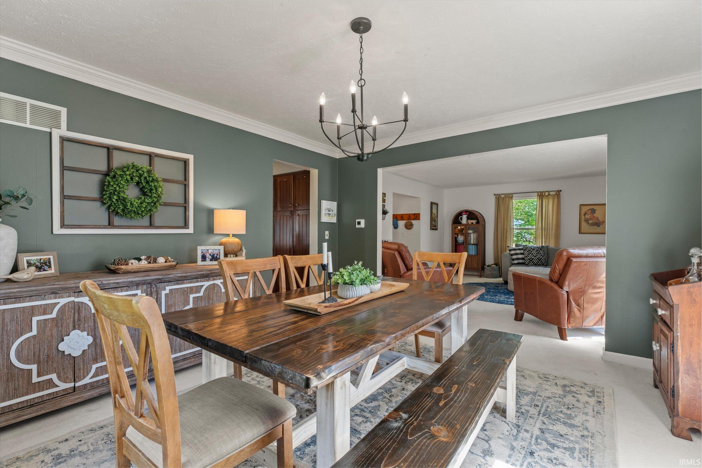 Dining area featuring a dark wood-finish trestle table, coordinating wood-finish seating, and a black metal chandelier