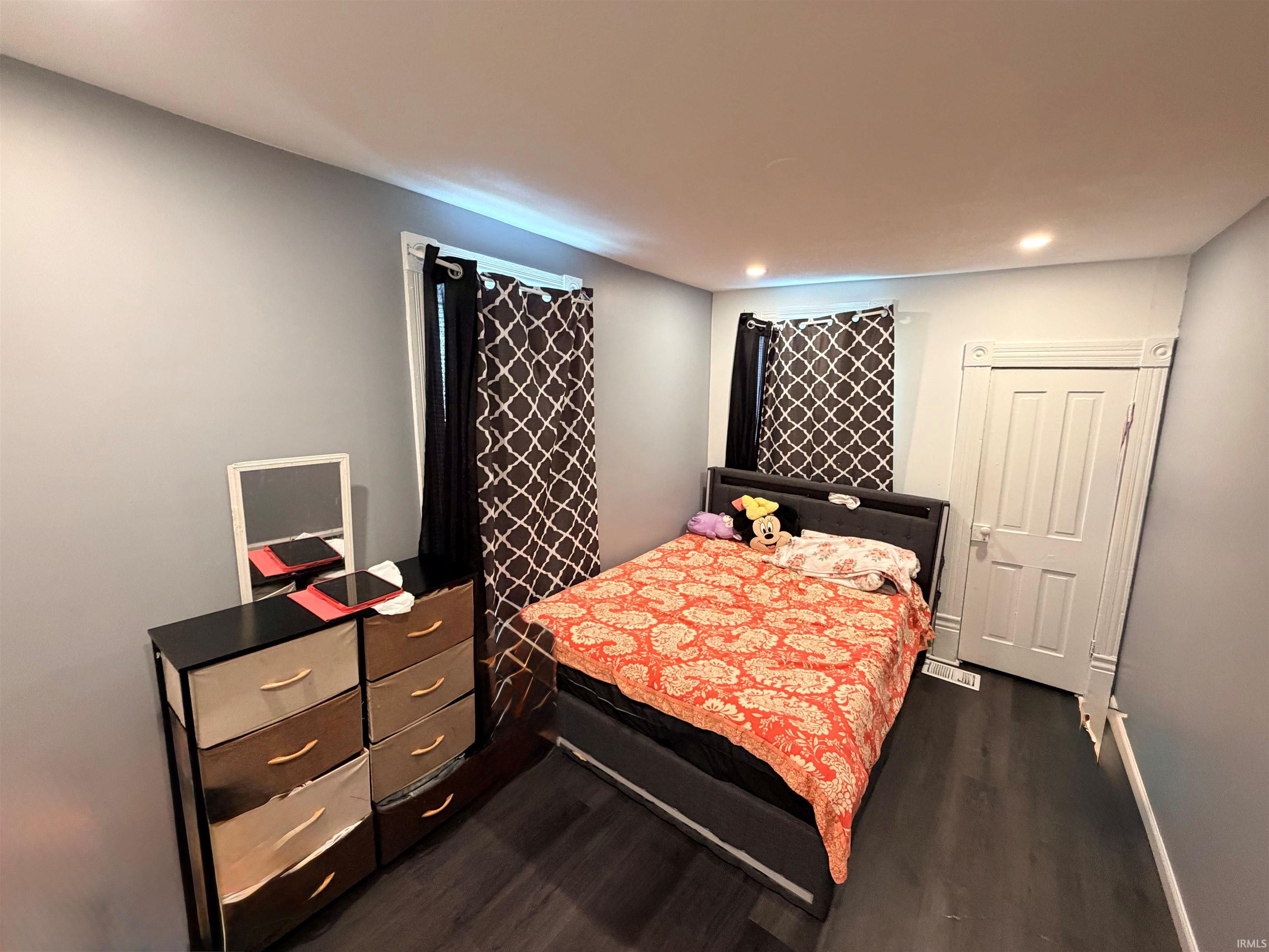 Room featuring dark wood-finish flooring, light gray wall paint, and white trim