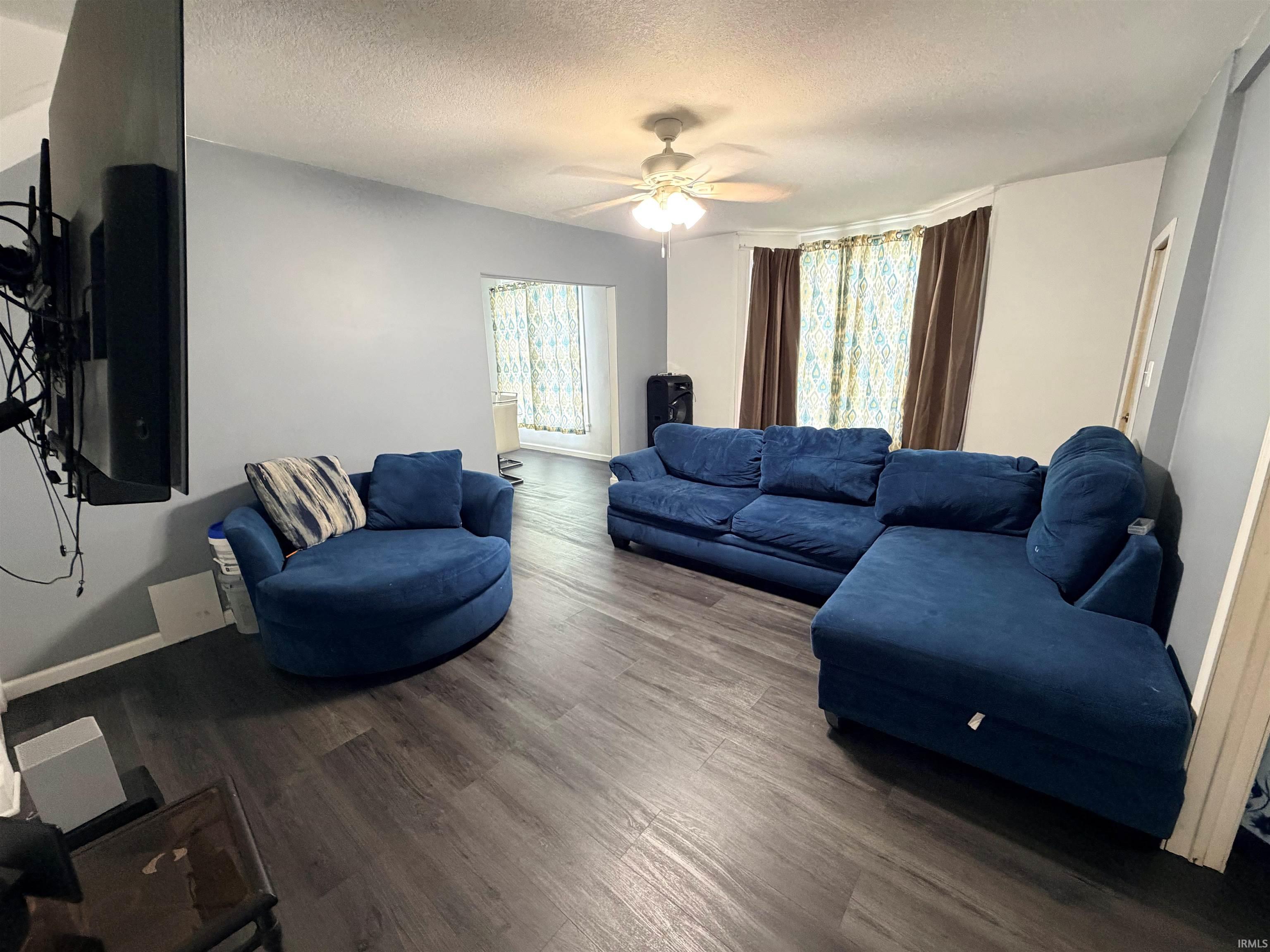 Spacious room featuring wood-finish flooring and light gray walls