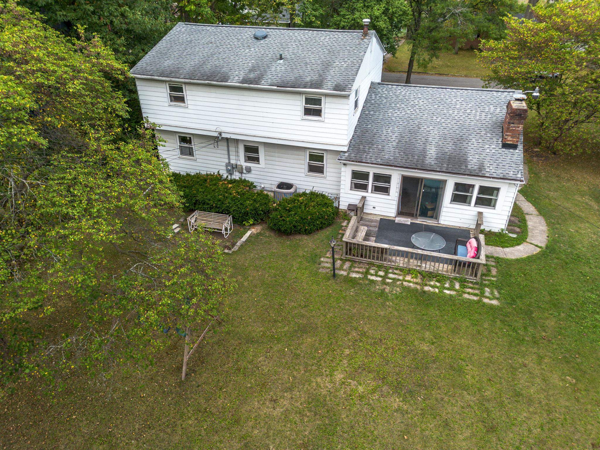 Rear exterior featuring white siding and a multi-level deck