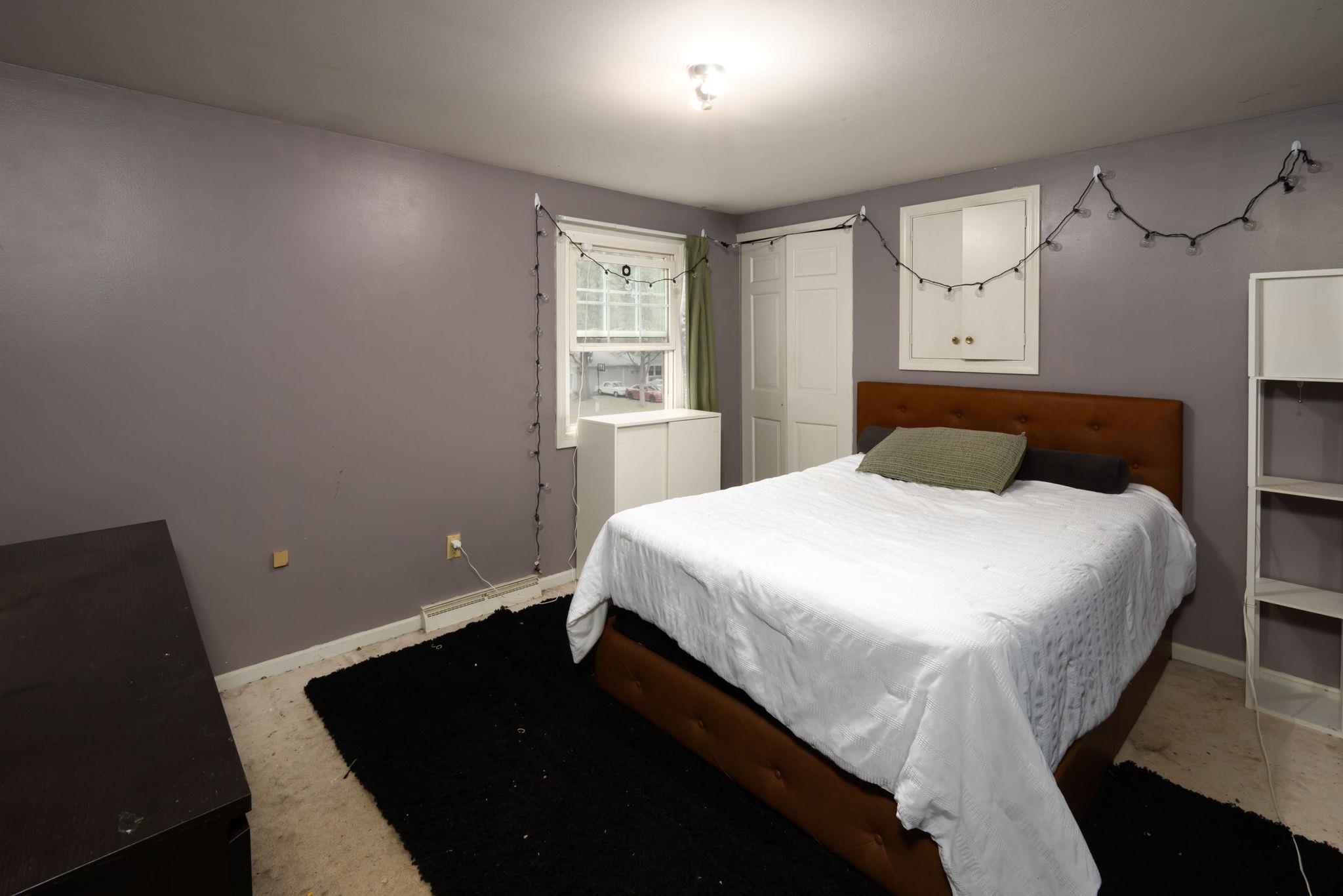 Bedroom with a built-in closet featuring bi-fold doors and a double-hung window