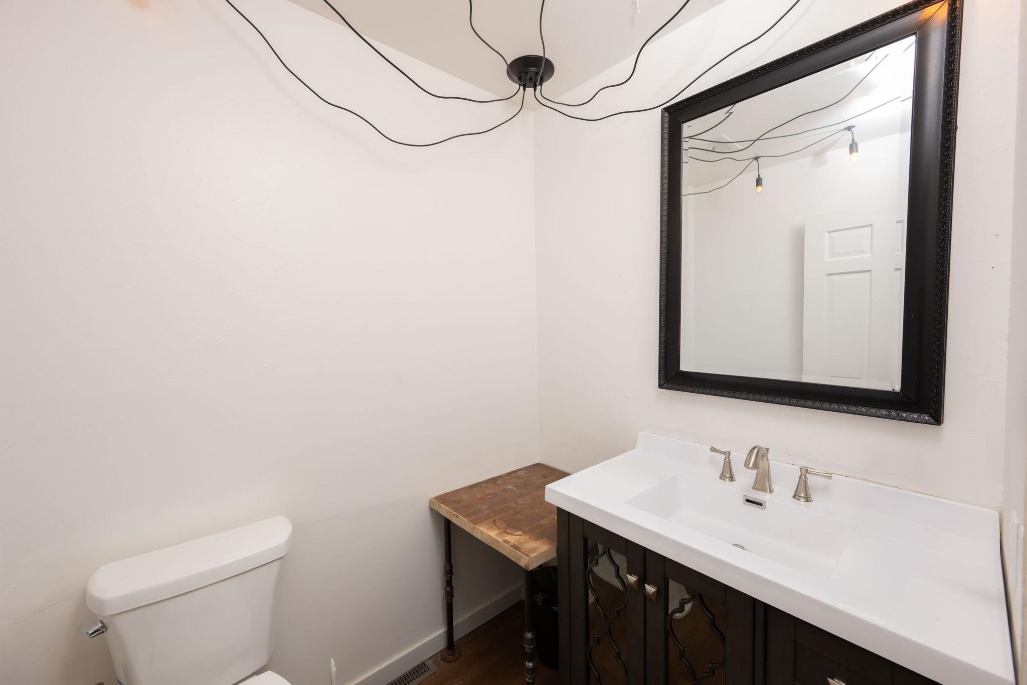 Bathroom featuring a vanity with a white countertop and undermount sink, brushed nickel faucet, and dark wood-finish cabinetry