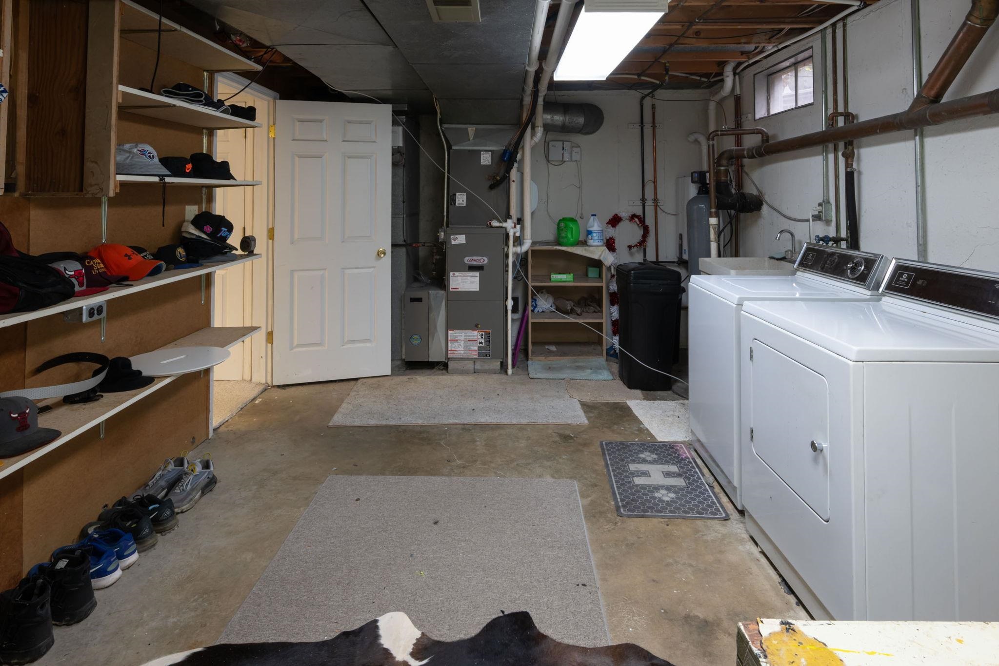 Dedicated laundry area featuring a washer and dryer, utility sink, and exposed plumbing