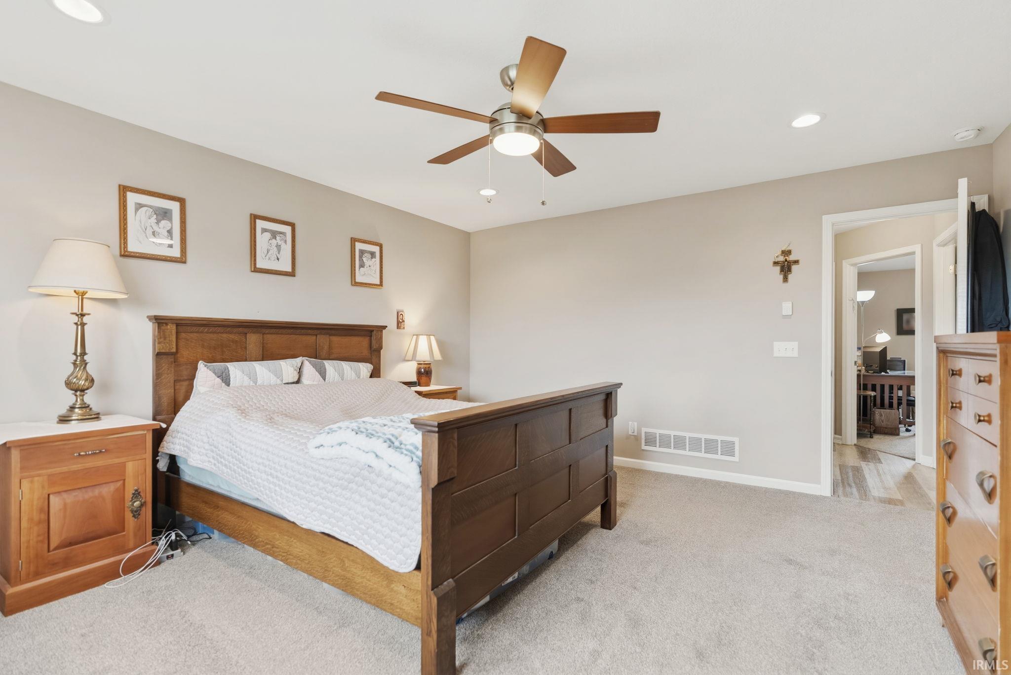Carpeted room with neutral wall tones and a ceiling fan with integrated lighting