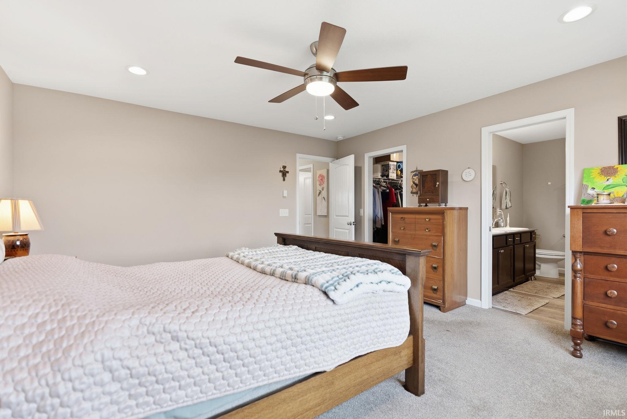 Carpeted bedroom featuring neutral wall tones, recessed lighting, and a ceiling fan