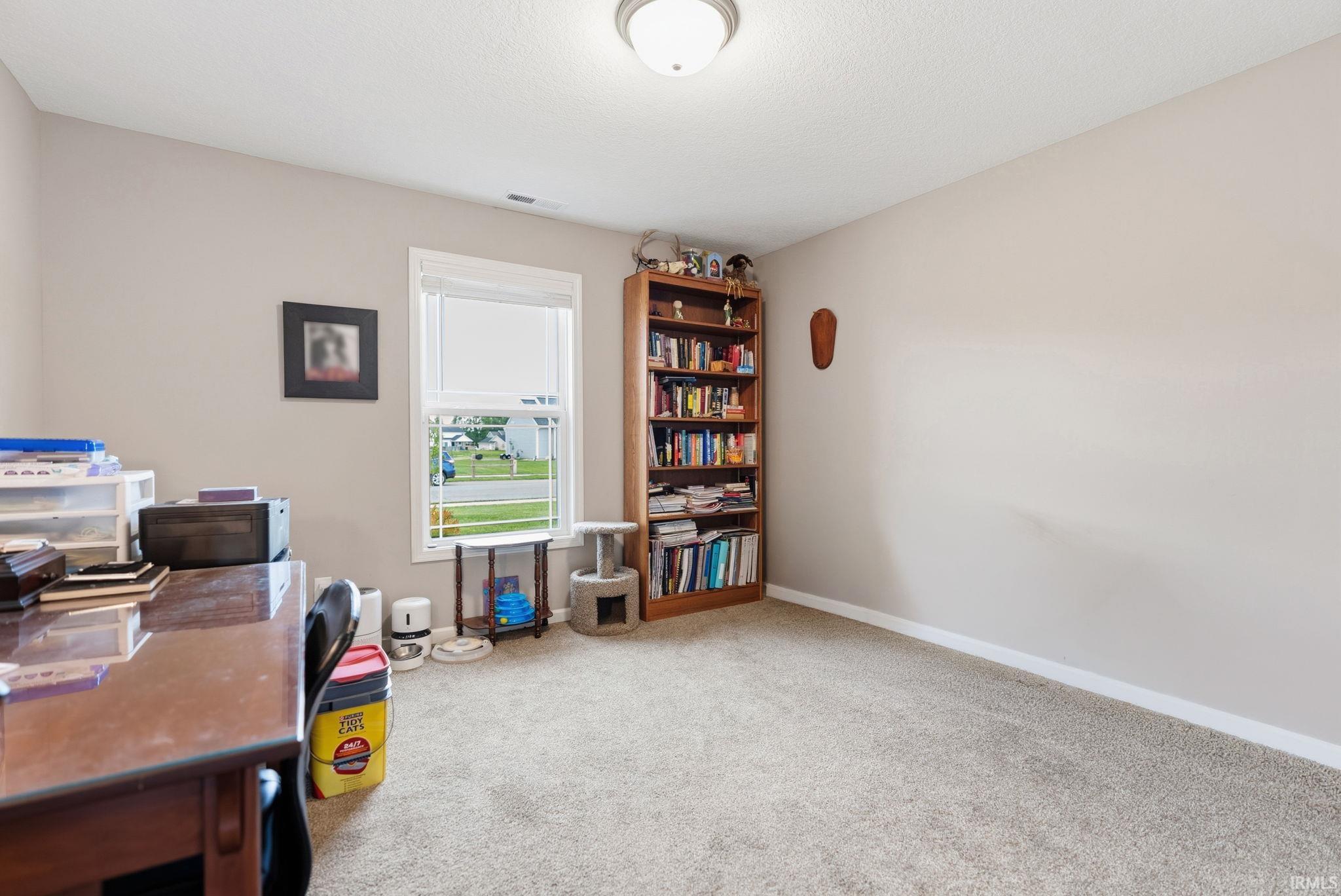 Carpeted room with neutral wall tones and white trim